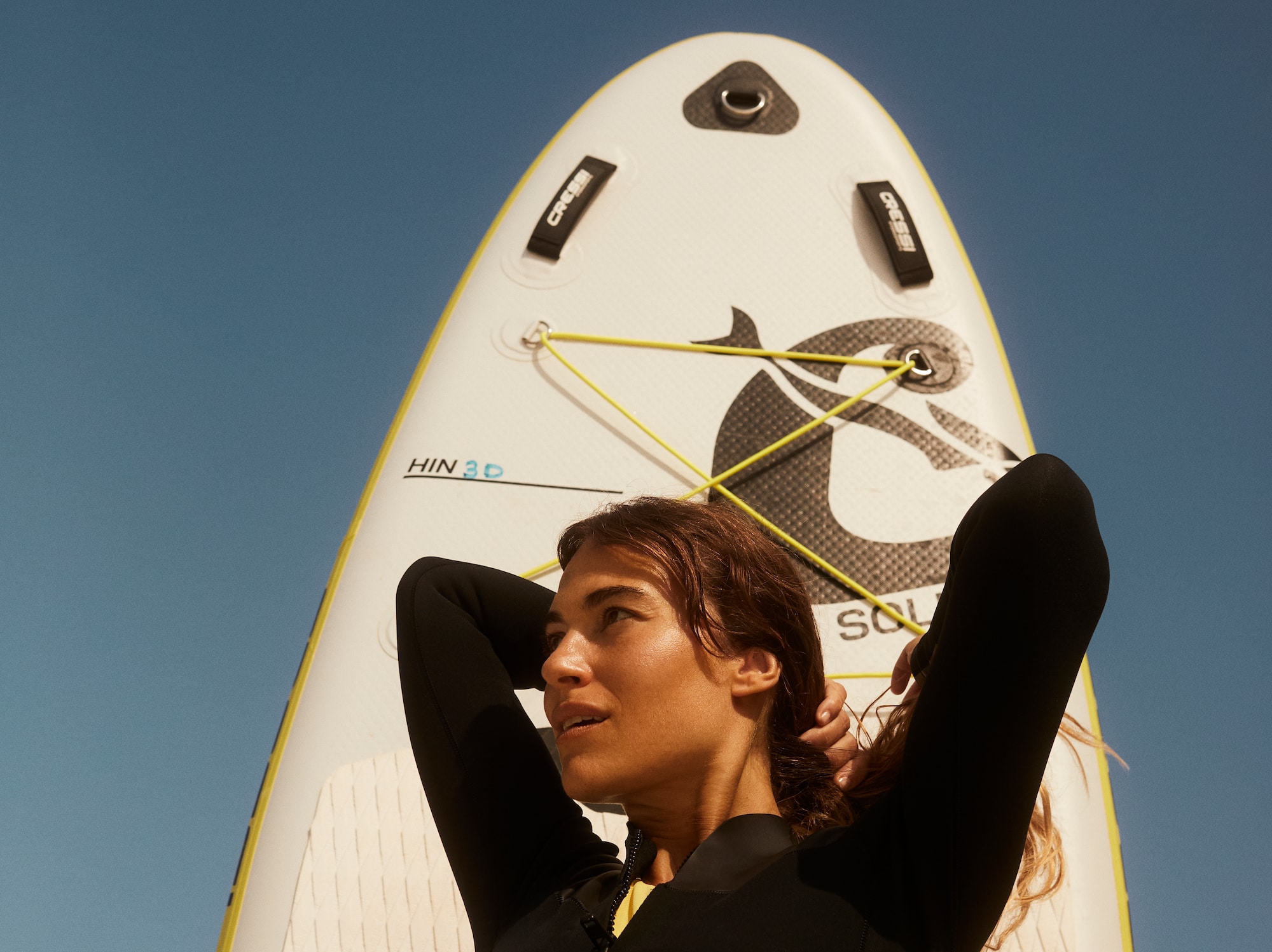 a woman in a wet suit holding a surfboard