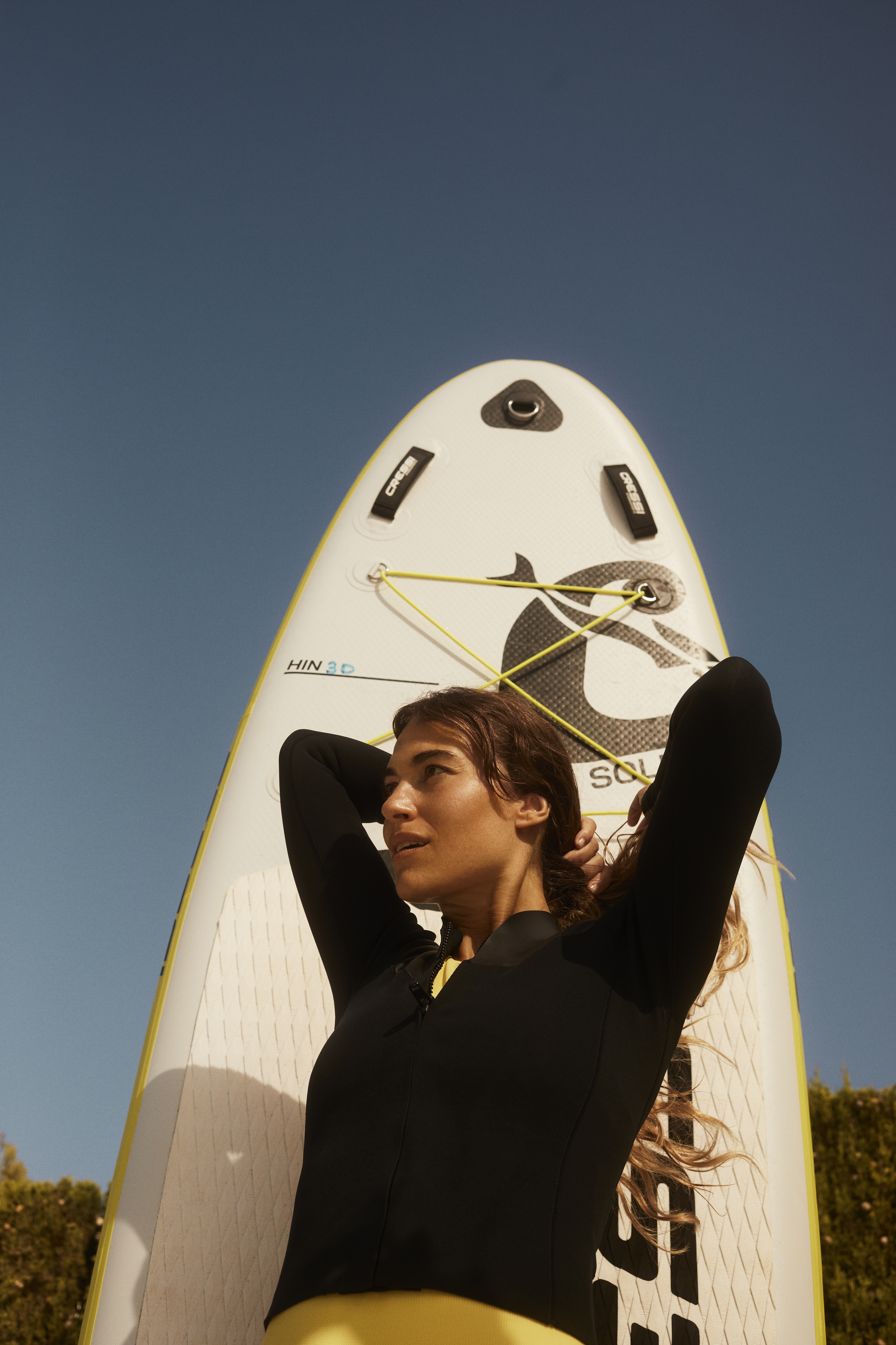 a woman in a wet suit holding a surfboard