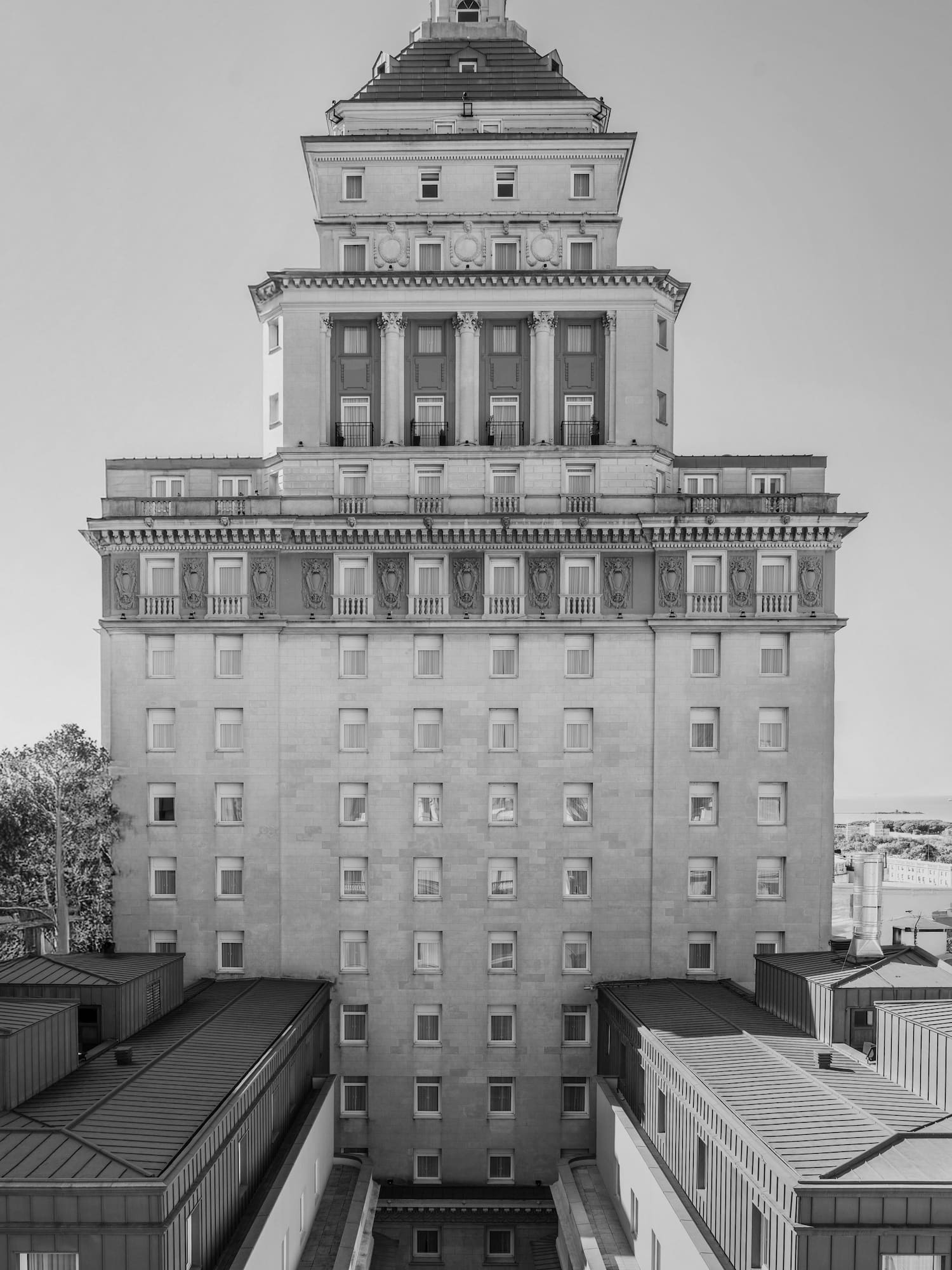 Black and white ornate classical building facade with columns and spire.