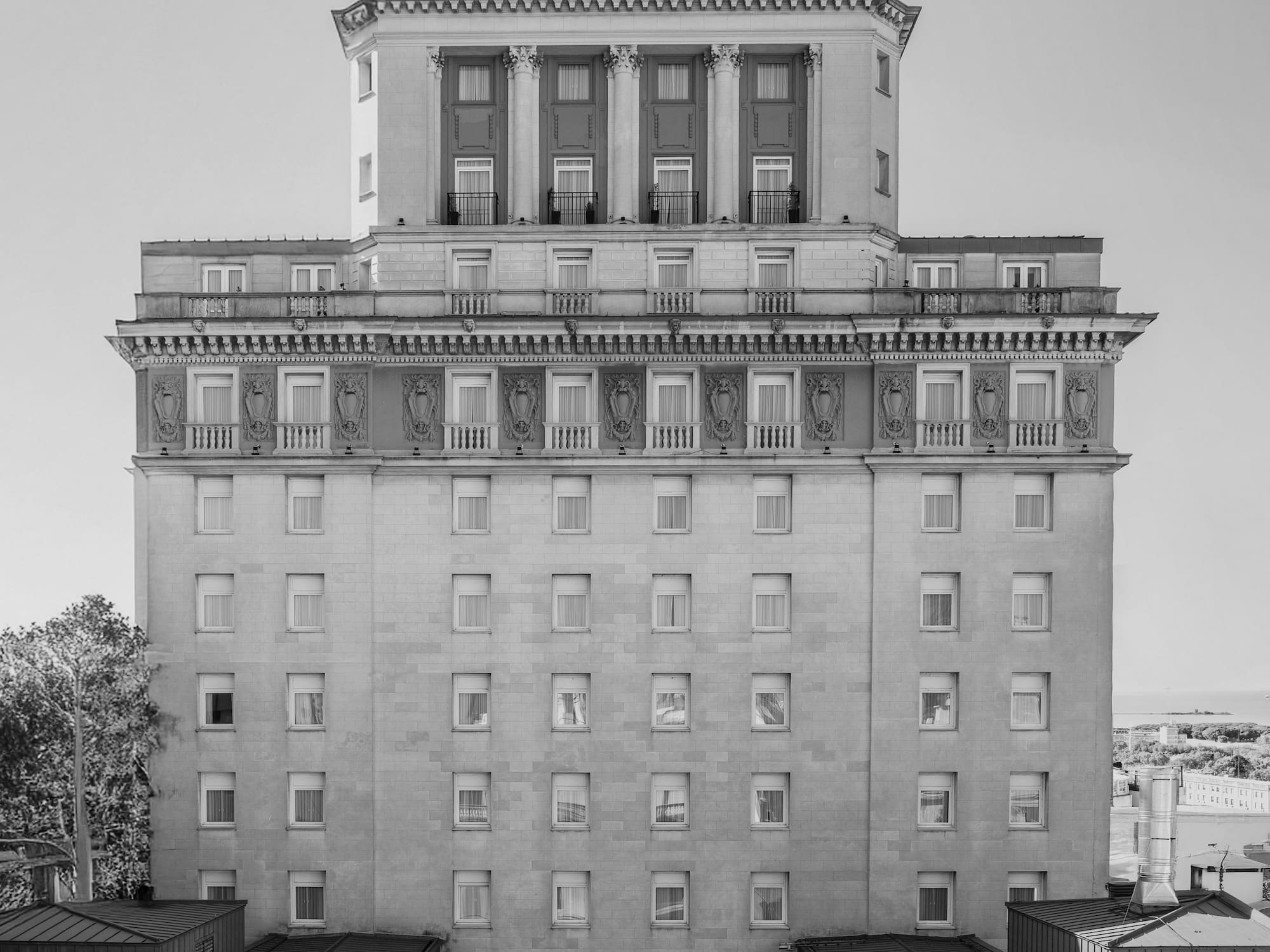 Ornate black and white historic hotel with classical columns and spire.