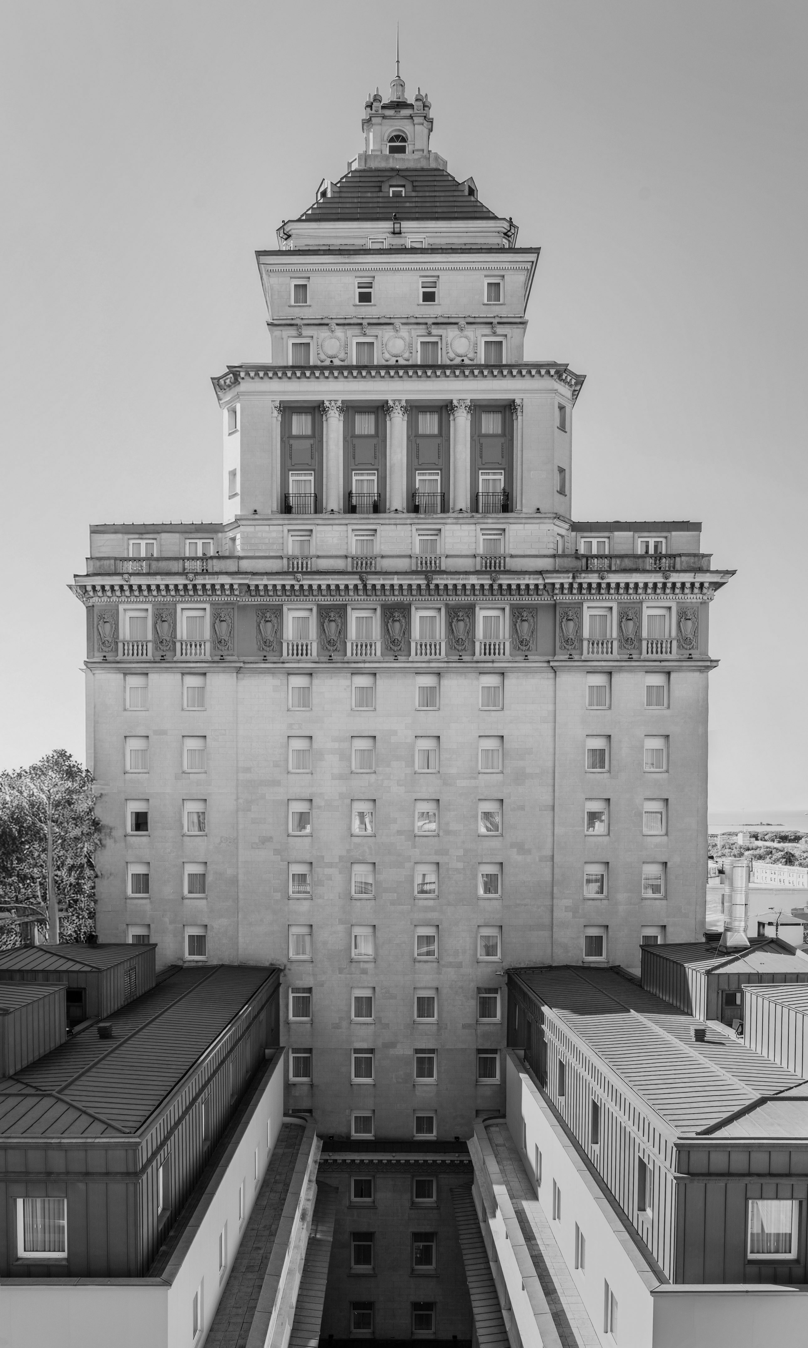 Ornate black and white historic hotel with classical columns and spire.