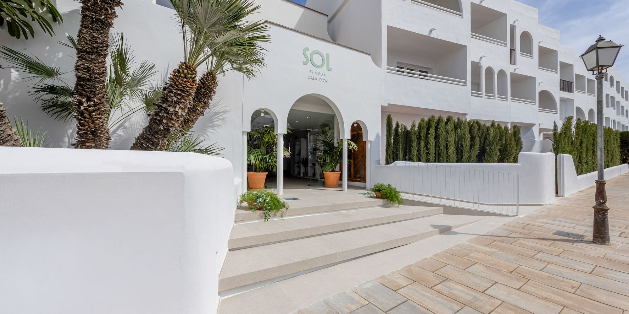 White Sol by Meliá Cala d'Or hotel entrance with palm trees and archways.