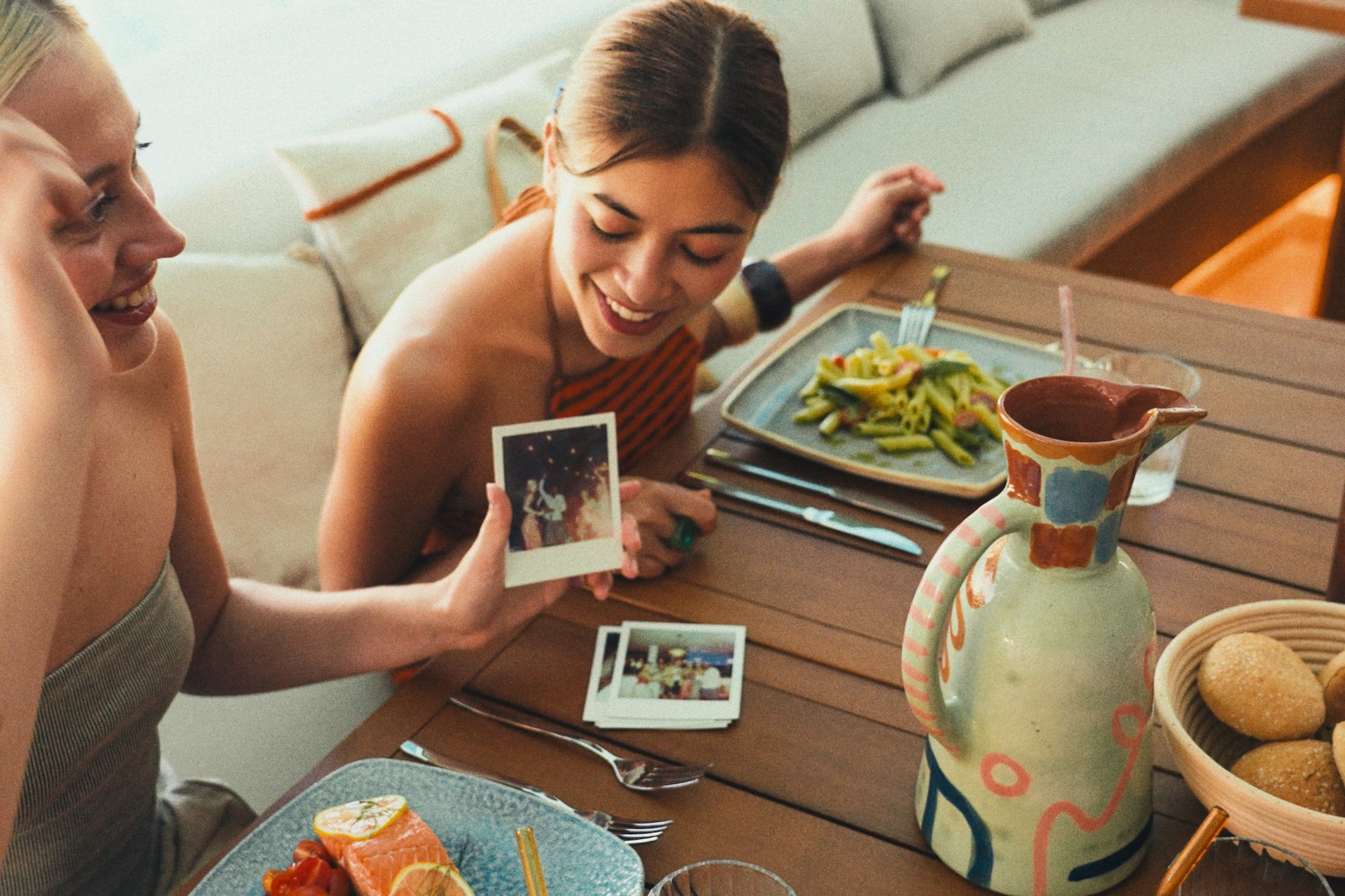 a woman sitting at a table with food and pictures