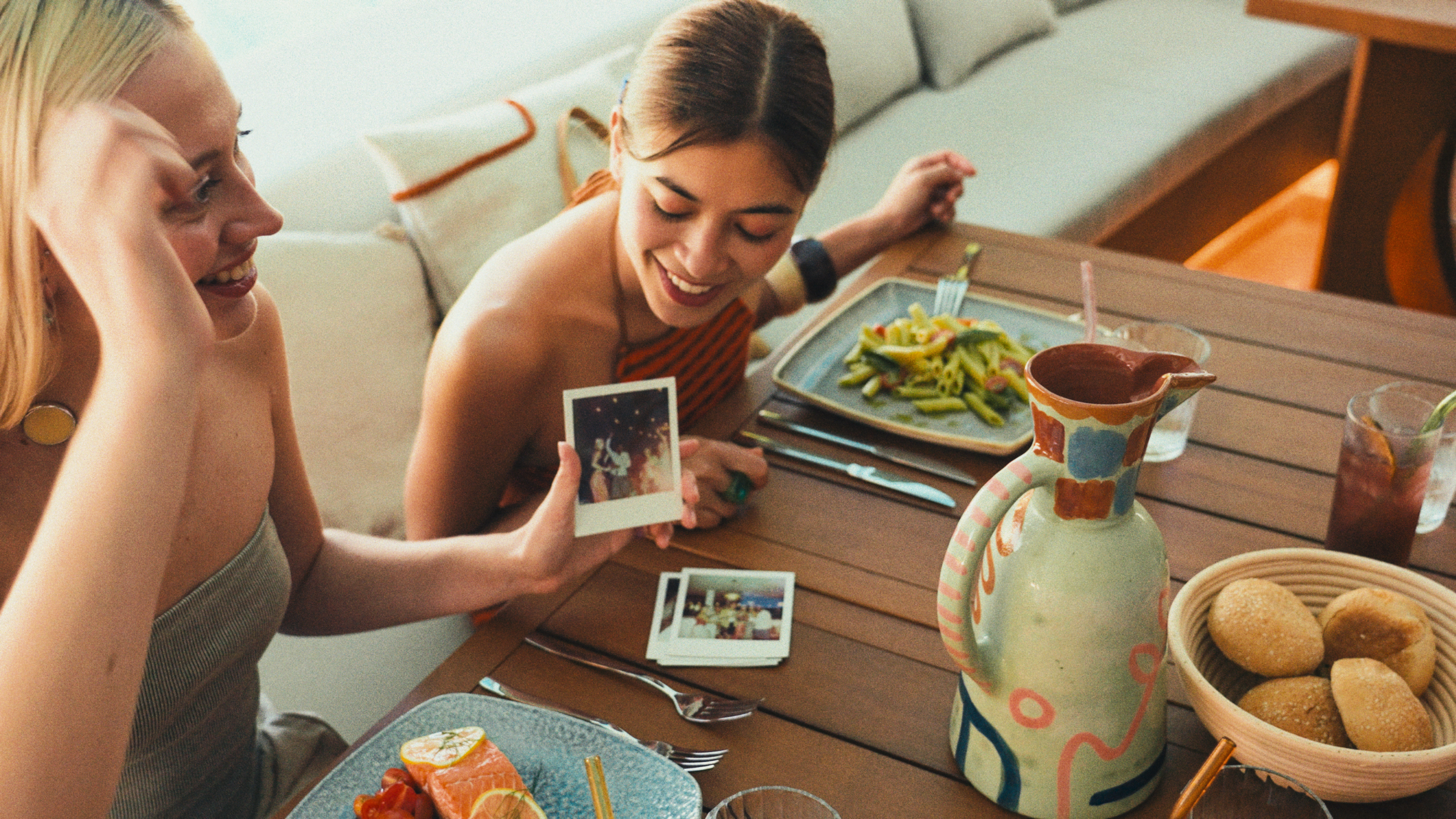 a woman sitting at a table with food and pictures