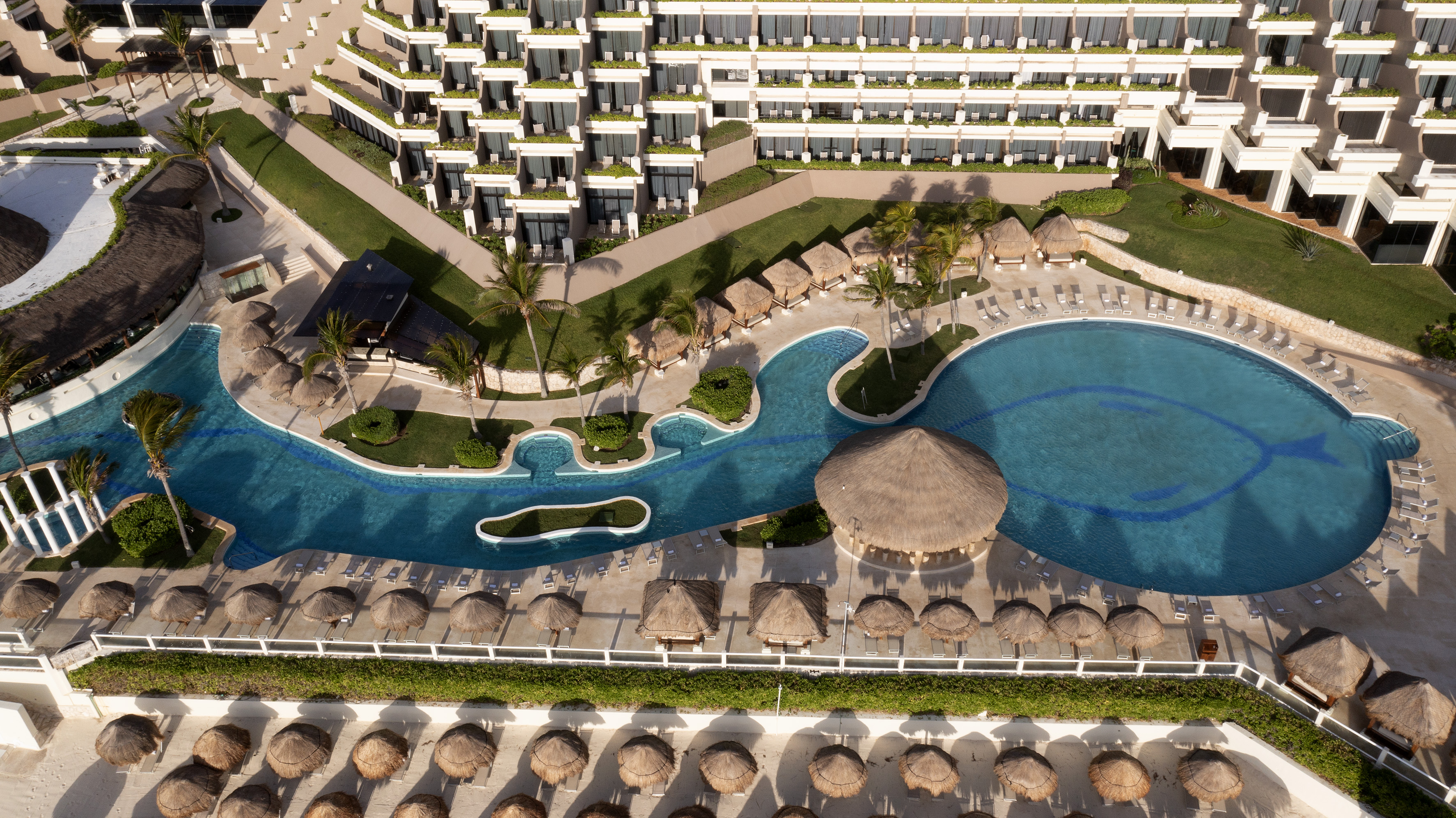 a pool and a building with a thatched roof