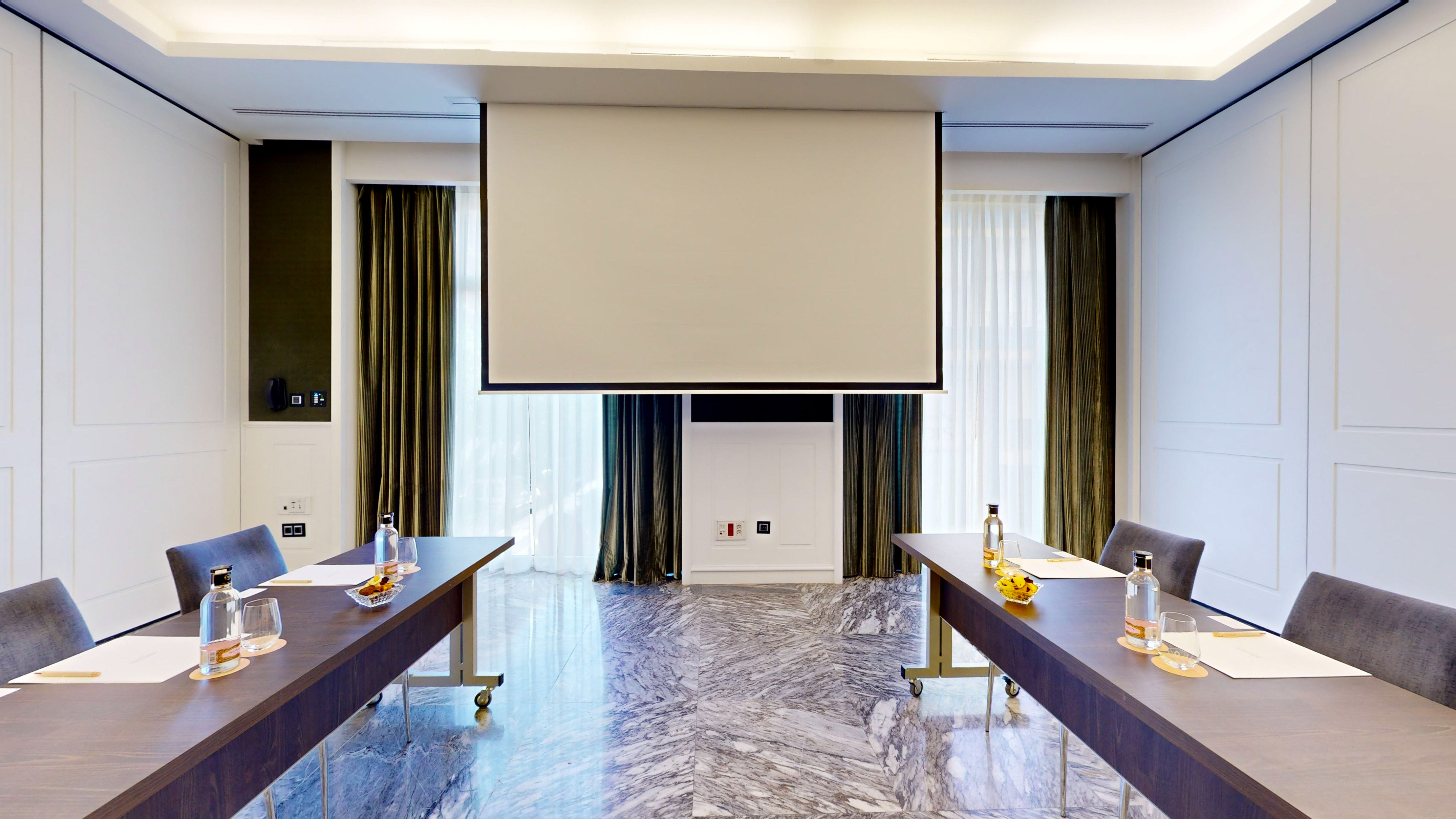Modern conference room with projector screen, tables, and marble floor.
