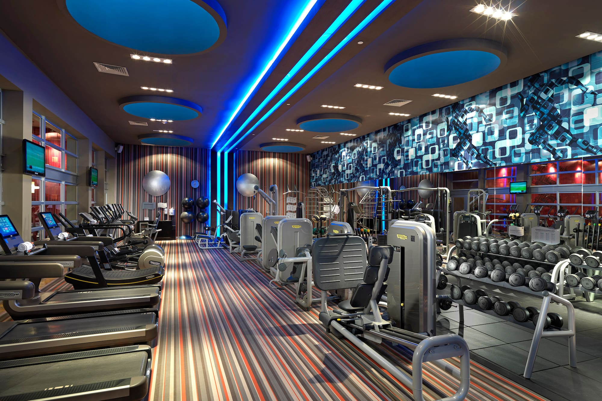 a room with exercise equipment and a blue and white wall