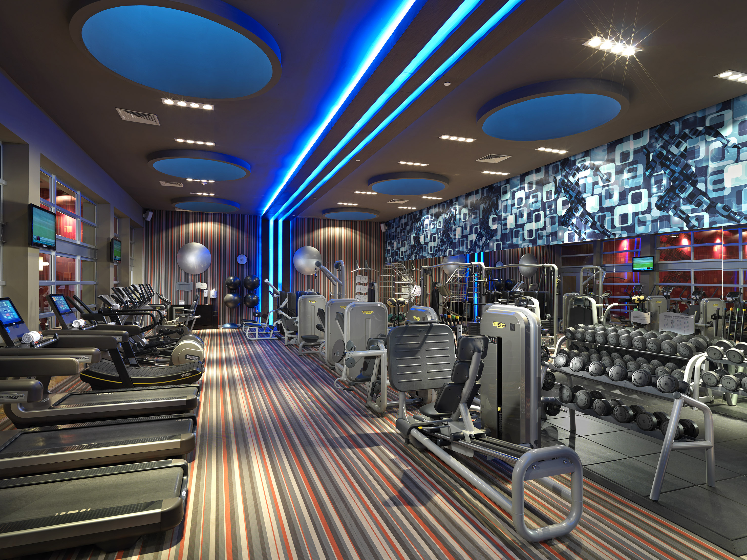 a room with exercise equipment and a blue and white wall