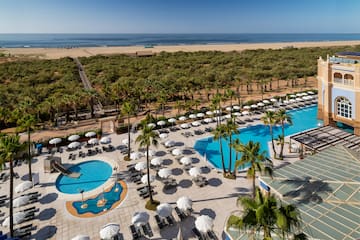 a swimming pool and trees by a beach