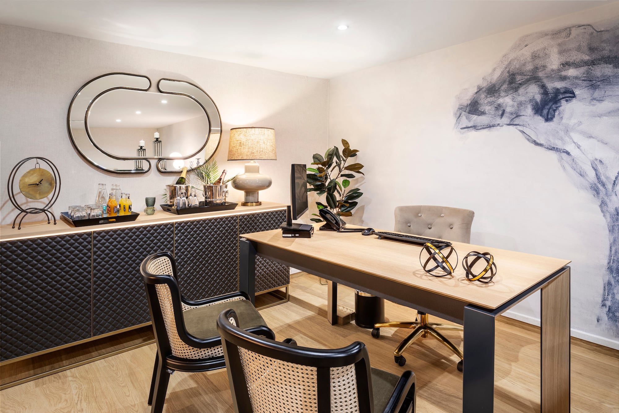 Modern executive office with wooden desk, stylish chairs, and bar credenza.