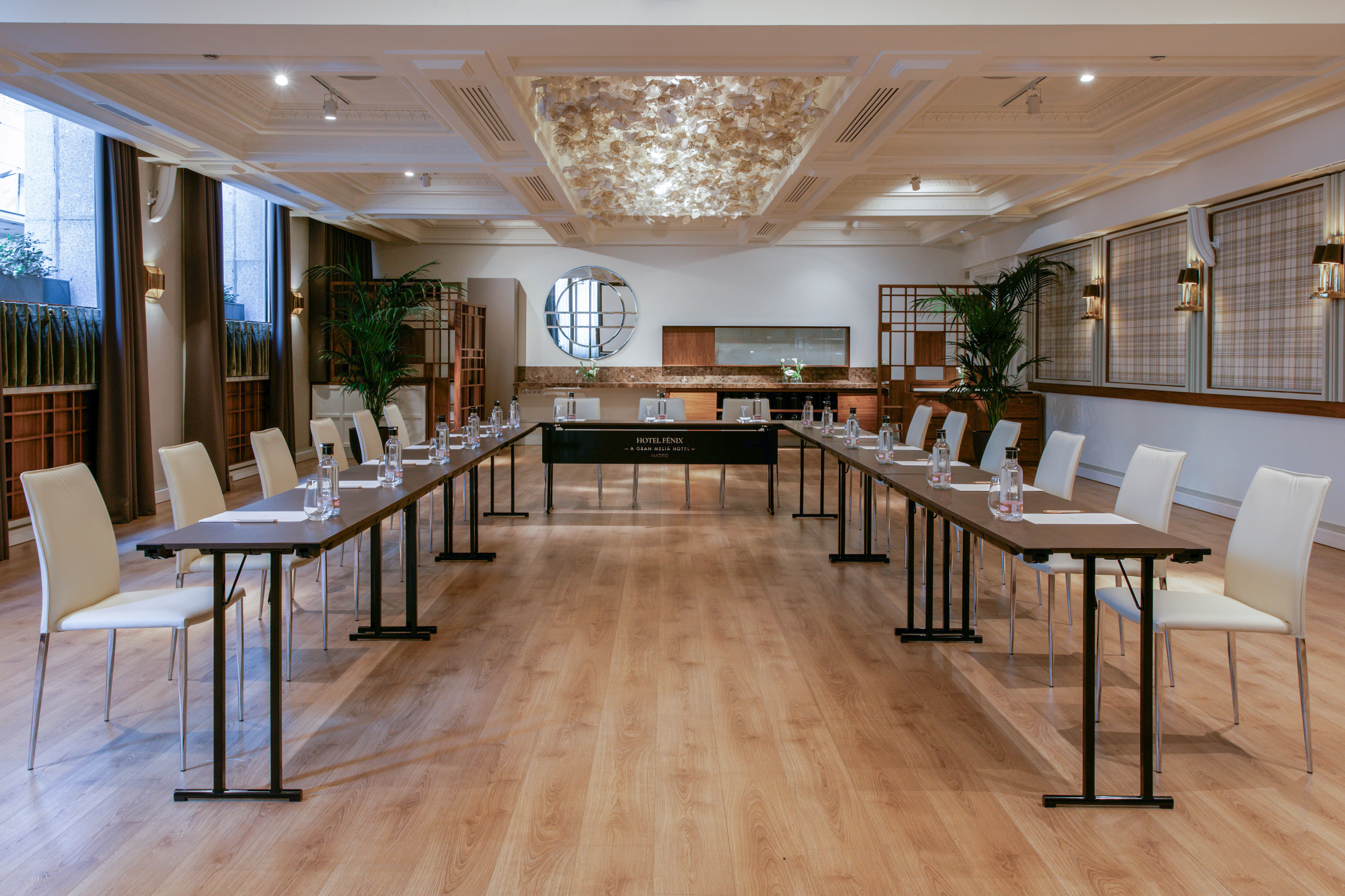 Hotel Fenix conference room with U-shaped table, white chairs, and elegant decor.