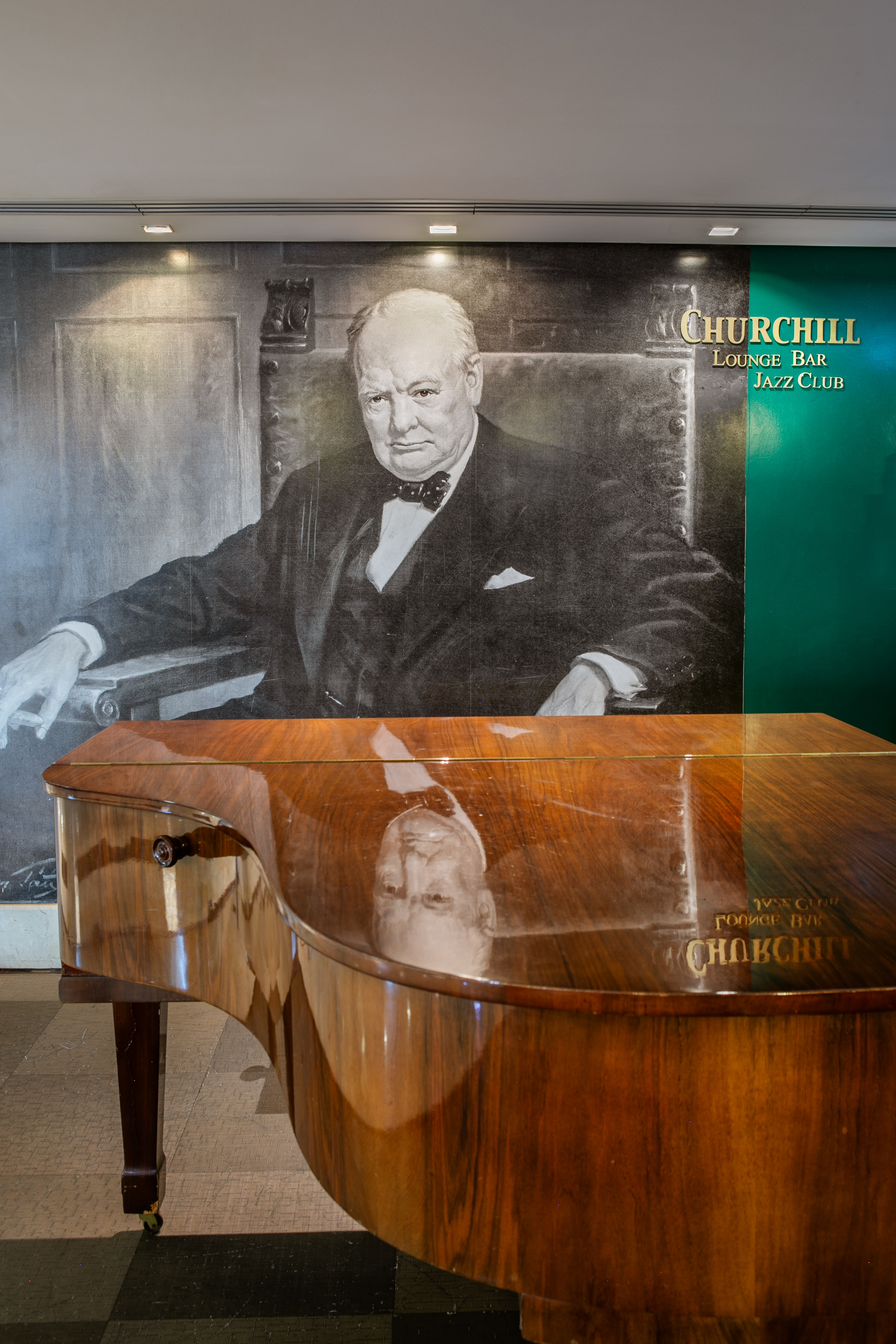 Winston Churchill mural above grand piano in Churchill Lounge Bar Jazz Club.