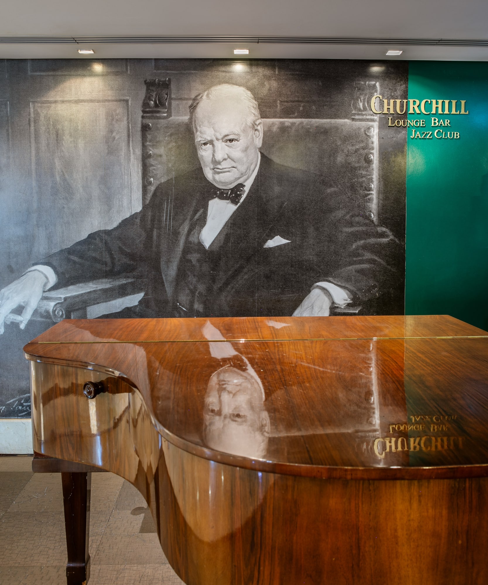 Winston Churchill mural above grand piano in Churchill Lounge Bar Jazz Club.