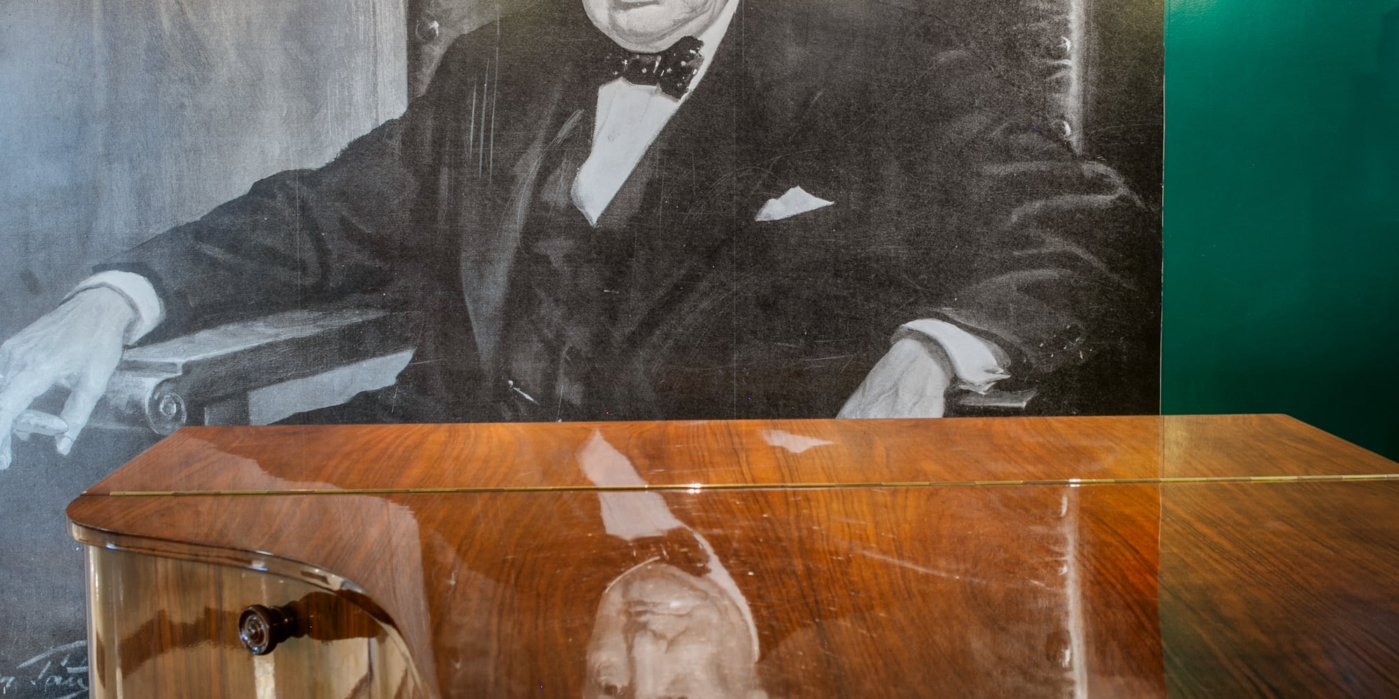 Winston Churchill portrait above glossy grand piano, jazz lounge.