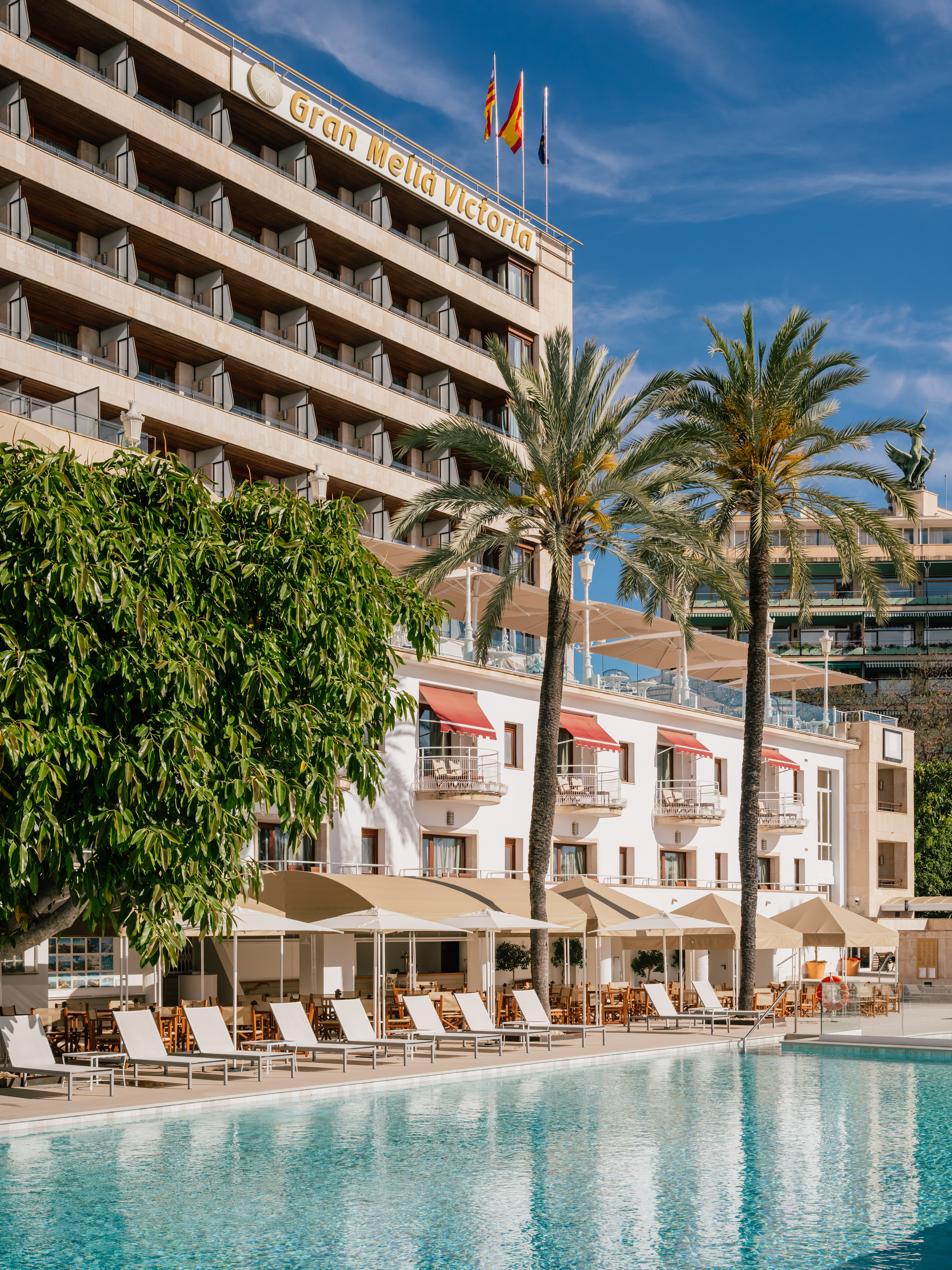 Gran Melia Victoria hotel, outdoor pool, palm trees, lounge chairs.