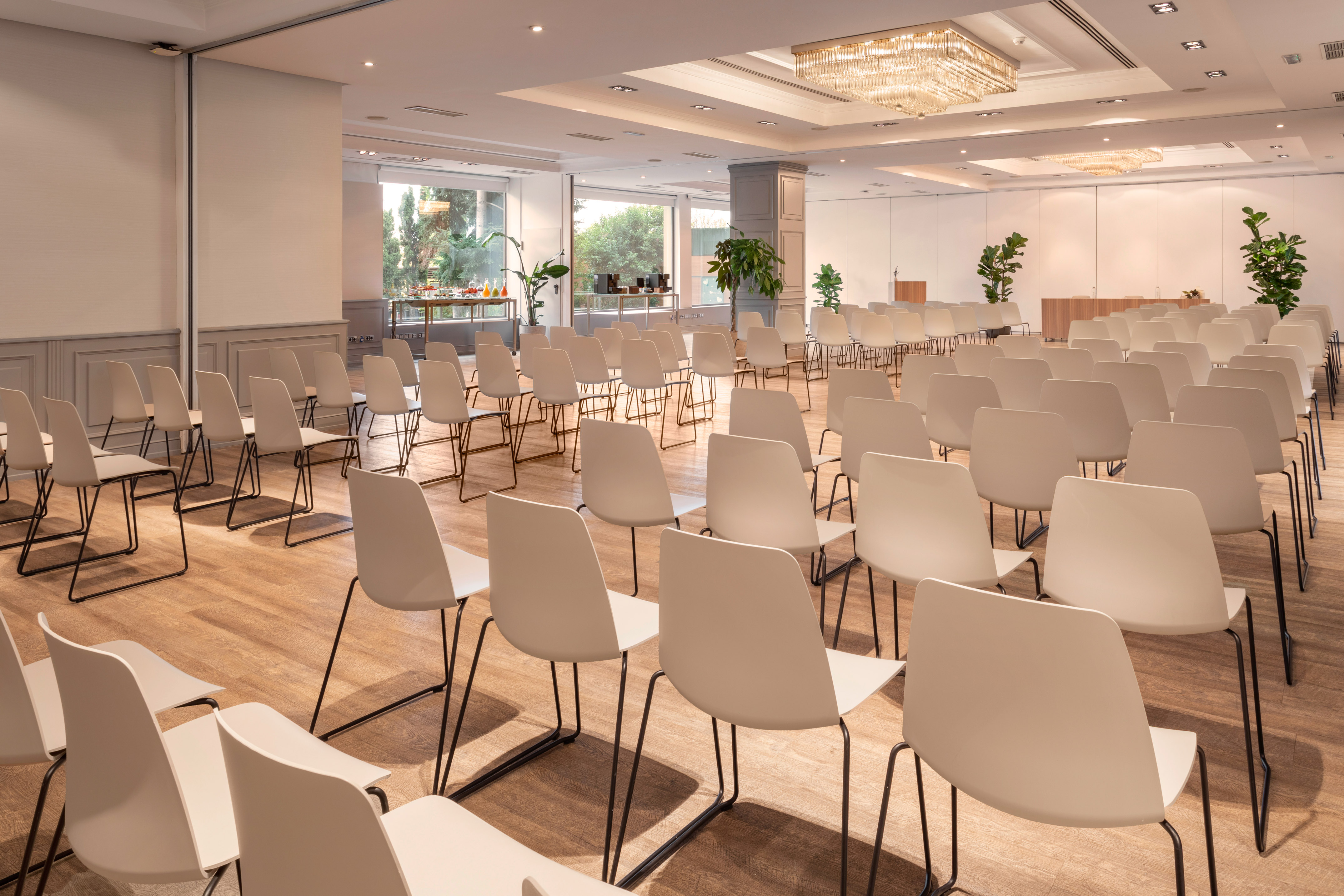Bright modern conference room with empty white chairs, set for an event.