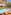 Hotel outdoor swimming pool with loungers, dining, and lush garden.