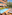 Hotel outdoor swimming pool with loungers, dining, and lush garden.