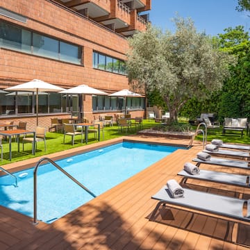 a pool with chairs and umbrellas in front of a building
