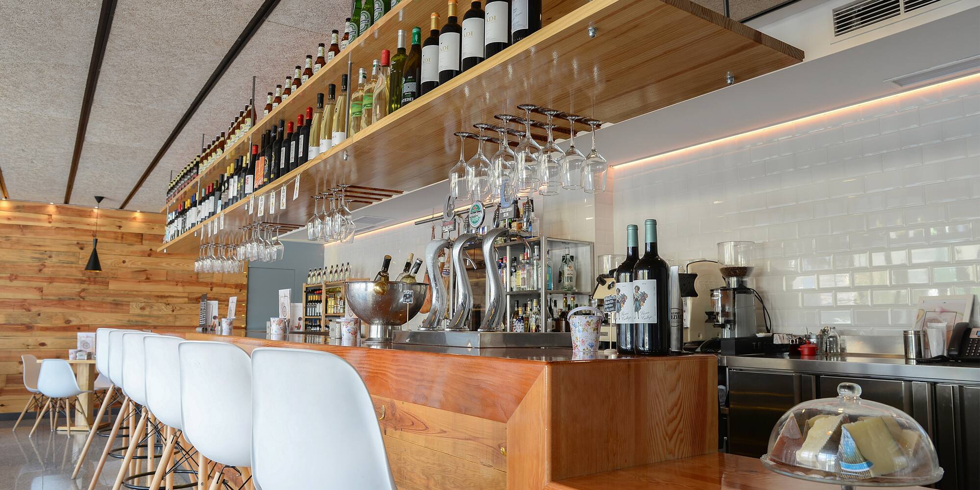a bar with wine glasses and bottles