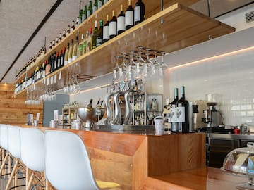 a bar with wine glasses and bottles
