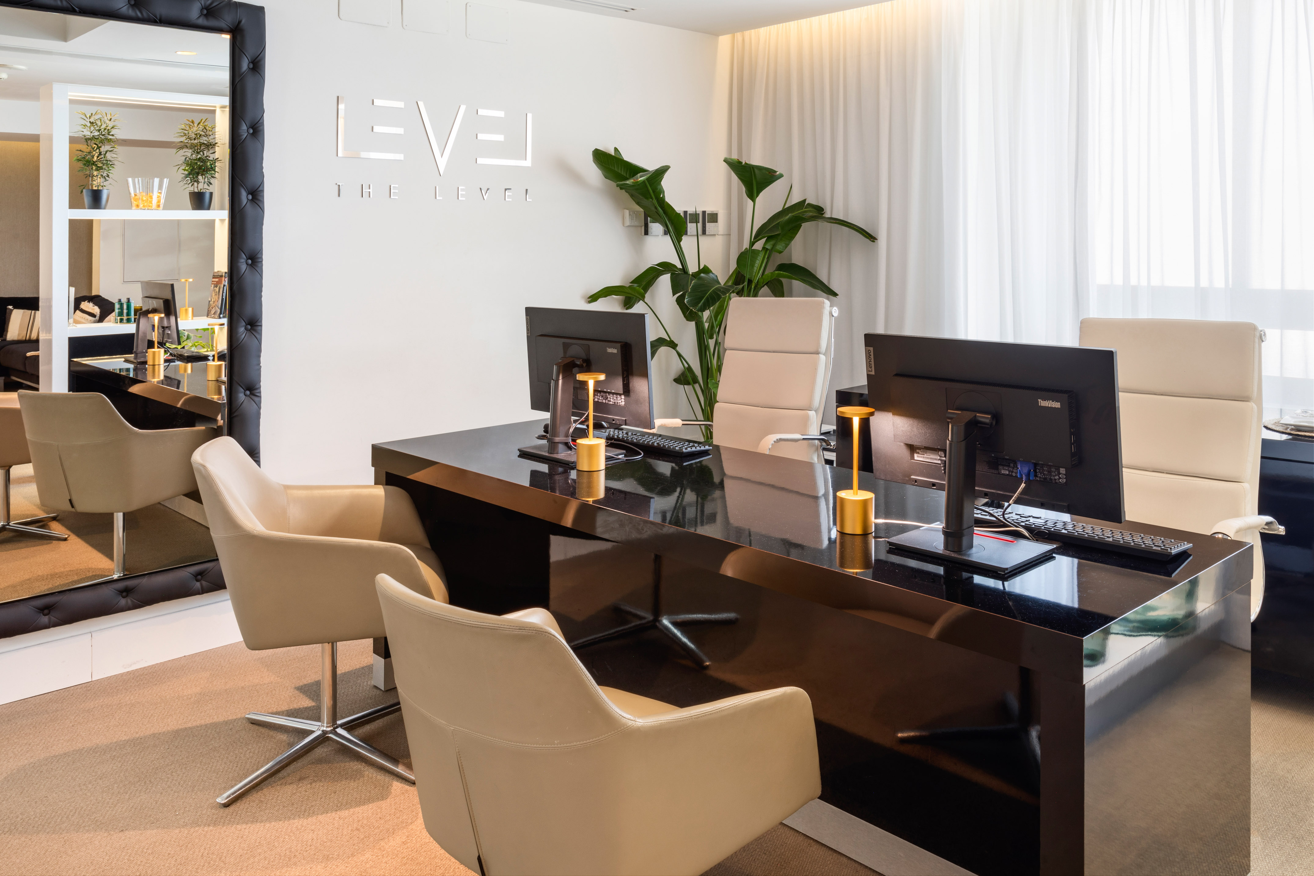 a desk with computers and chairs in a room