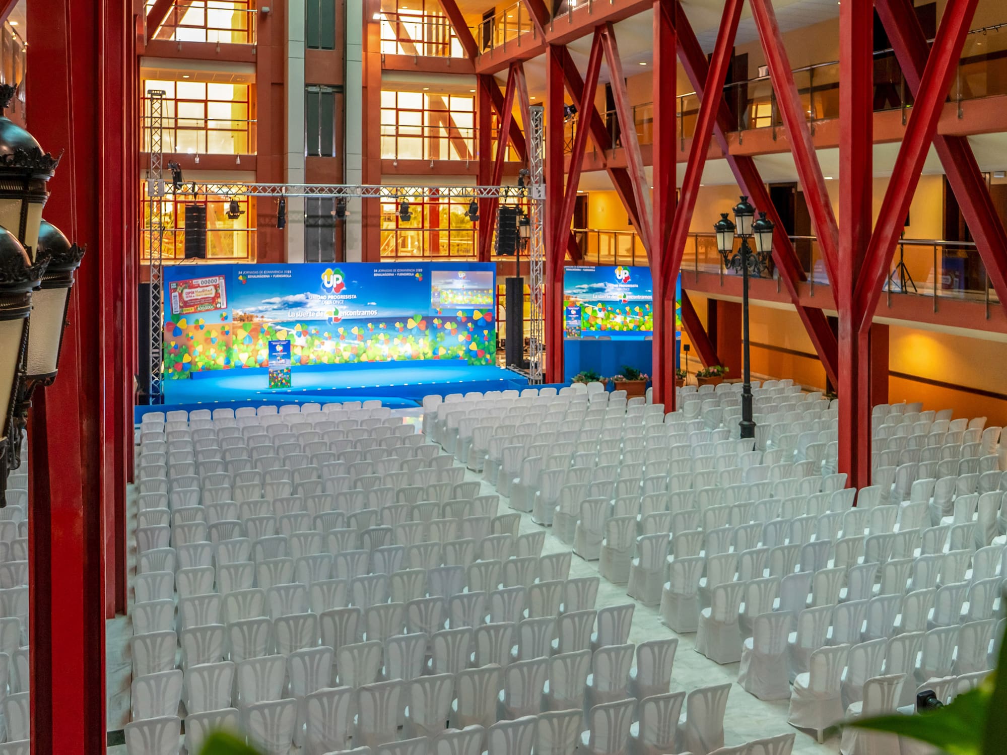 a large room with white chairs and a stage