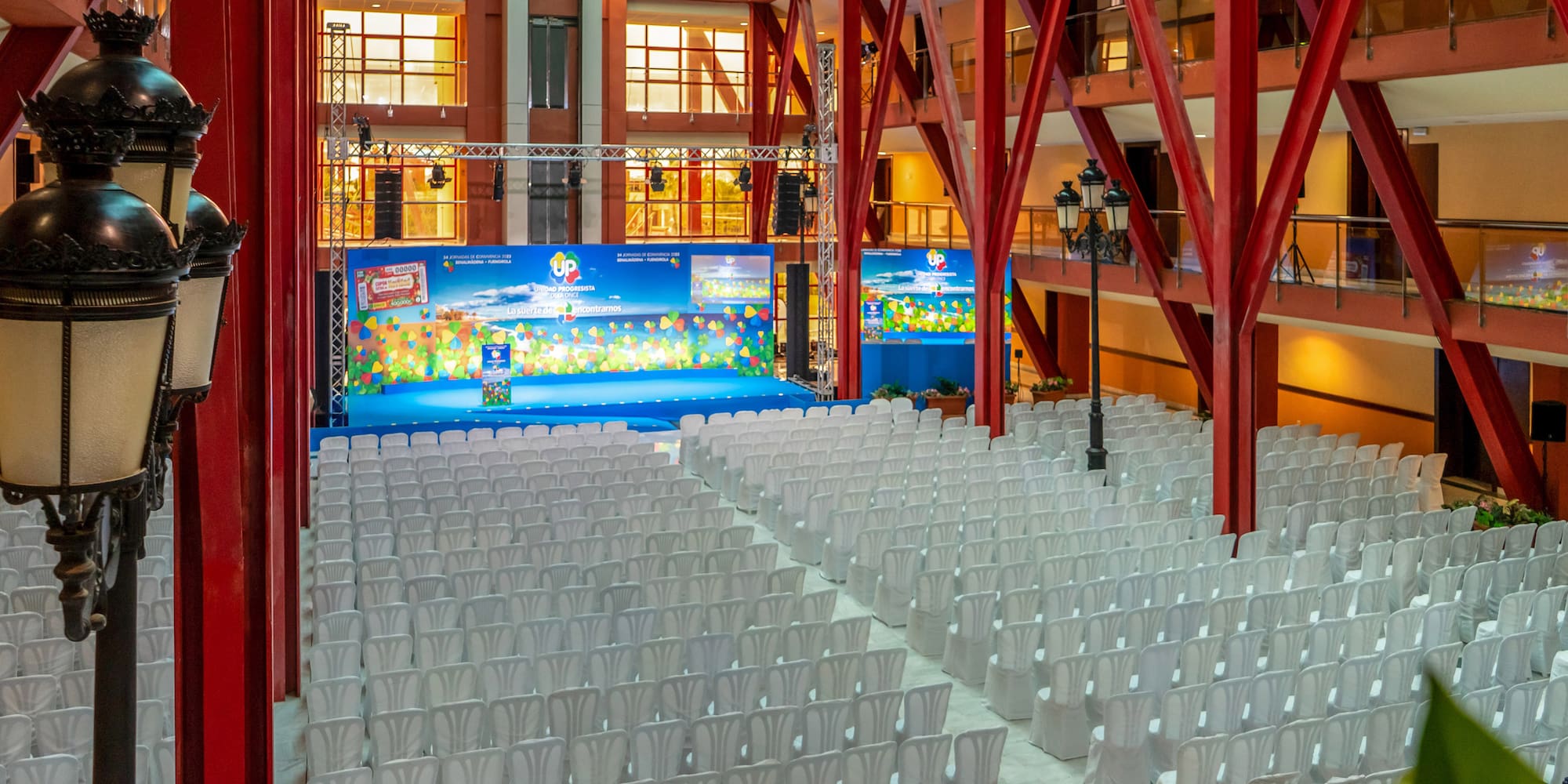 a large room with white chairs and a stage