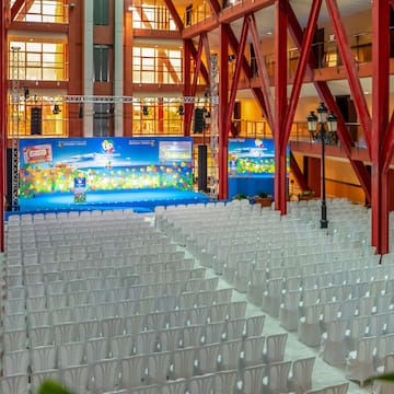 a large room with white chairs and a stage