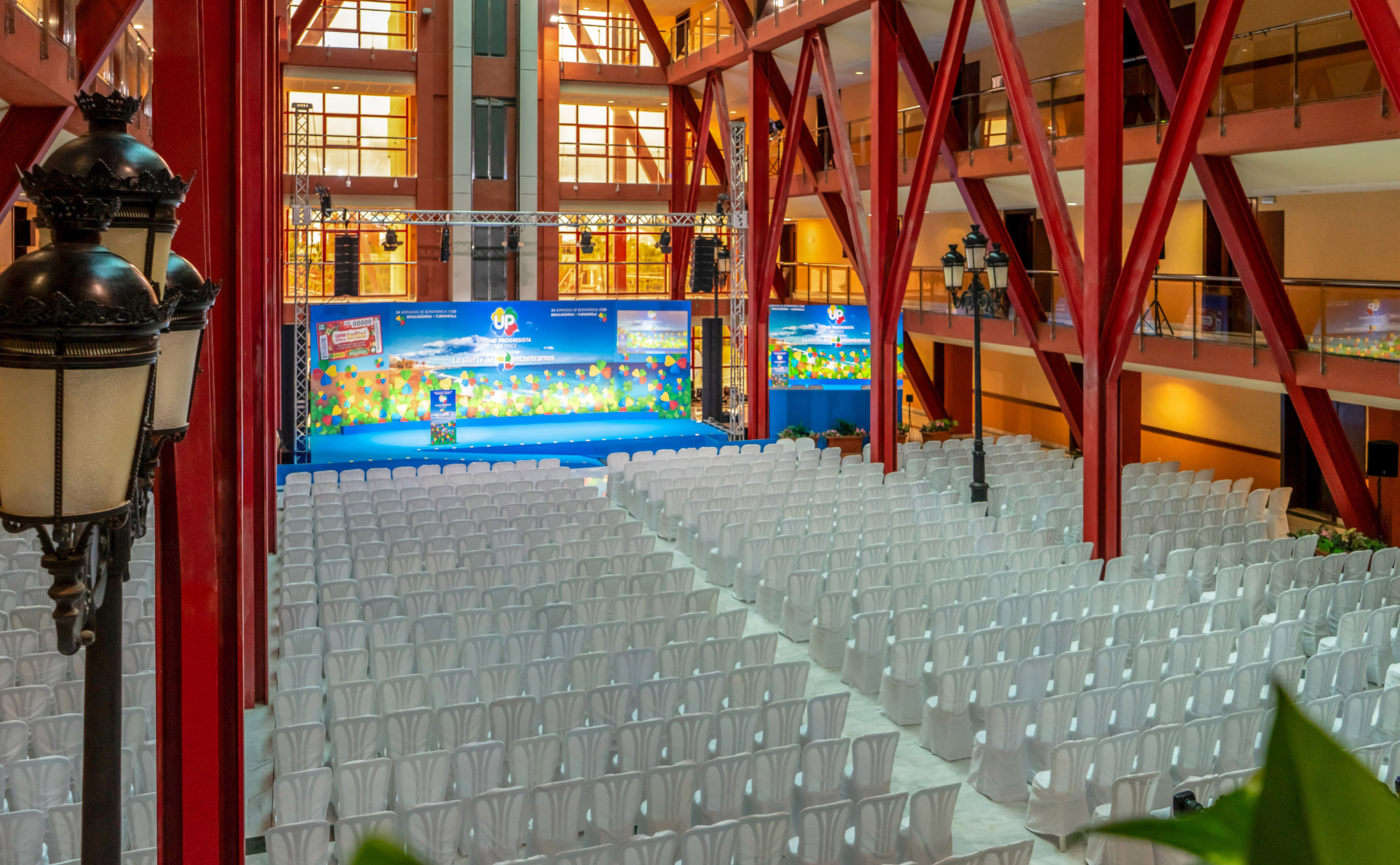 a large room with white chairs and a stage
