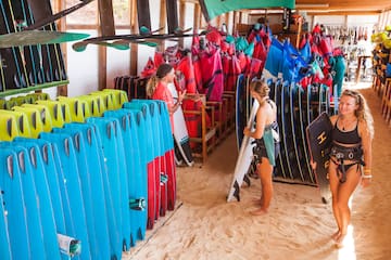 a woman holding a surfboard in a store
