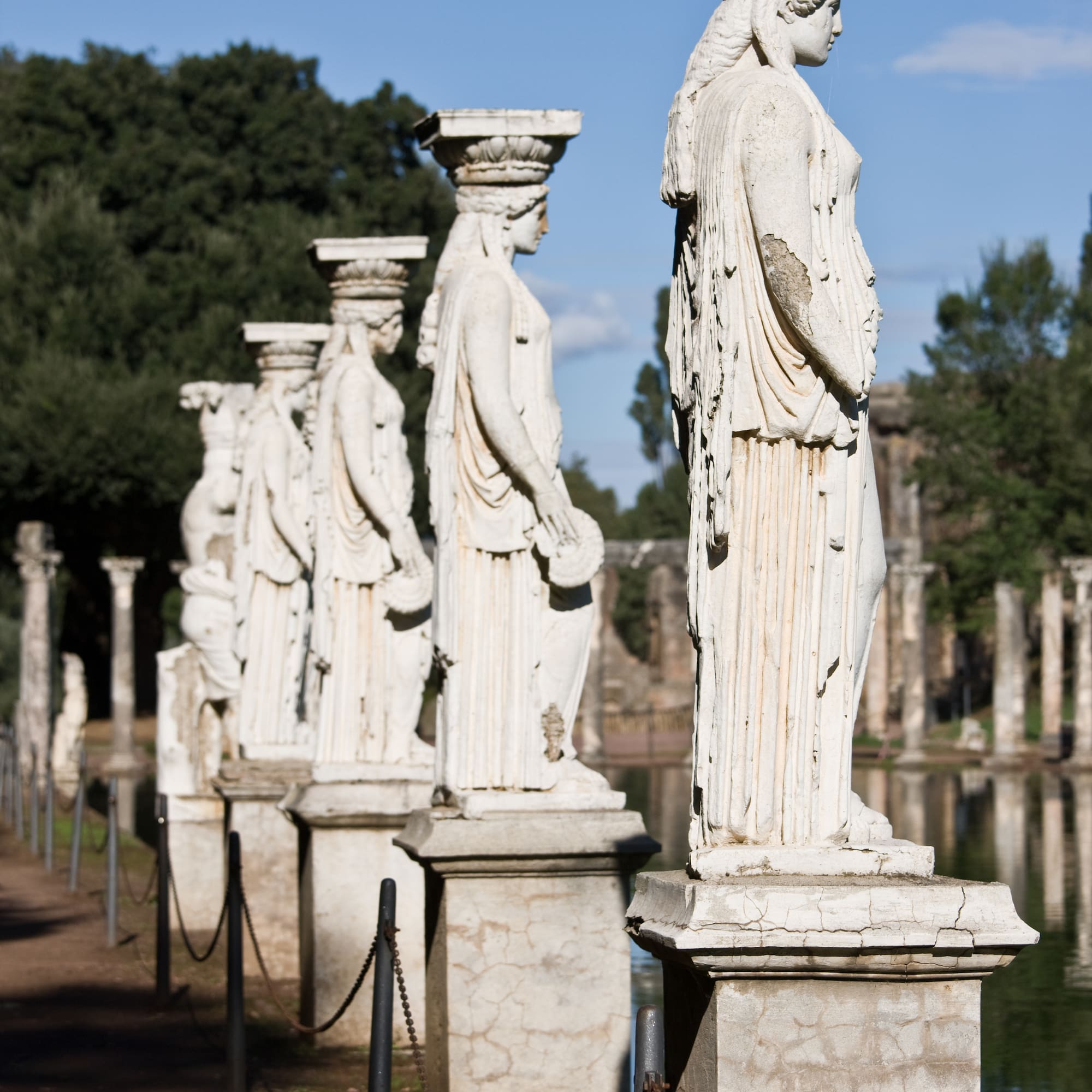 a row of statues on pillars