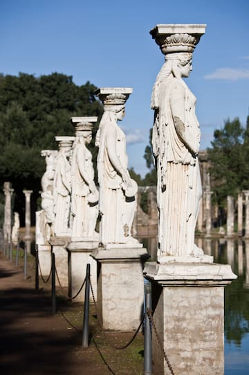 a row of statues on pillars