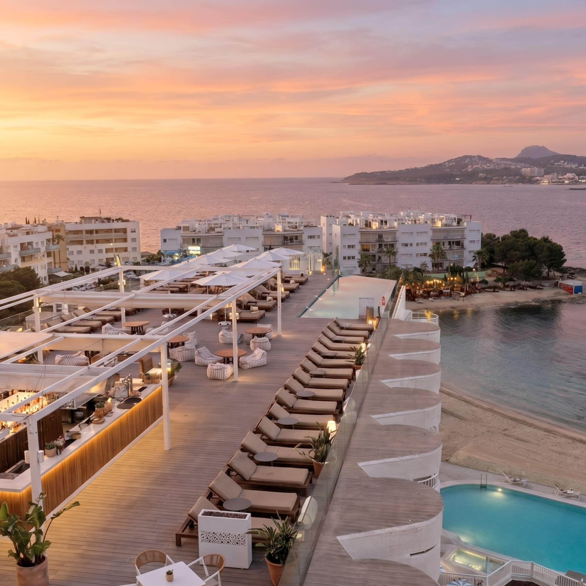 Coastal resort rooftop bar and pool at sunset, ocean and beach view.