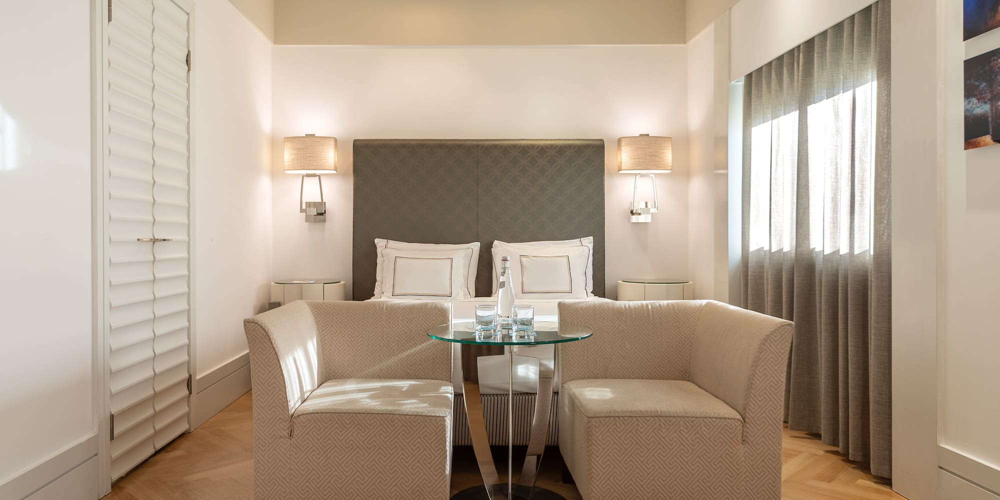 a room with a bed and two chairs