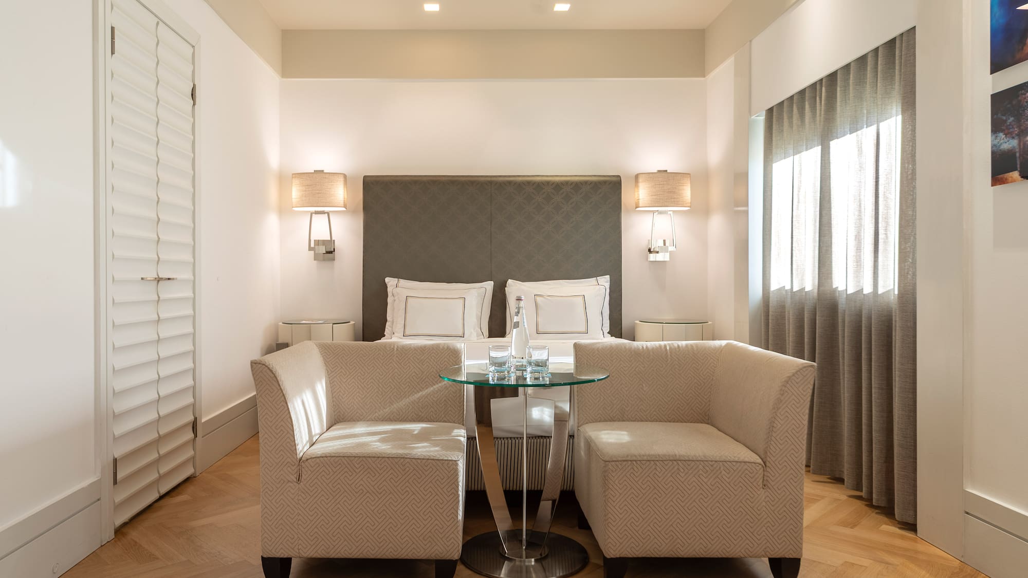 a room with a bed and two chairs