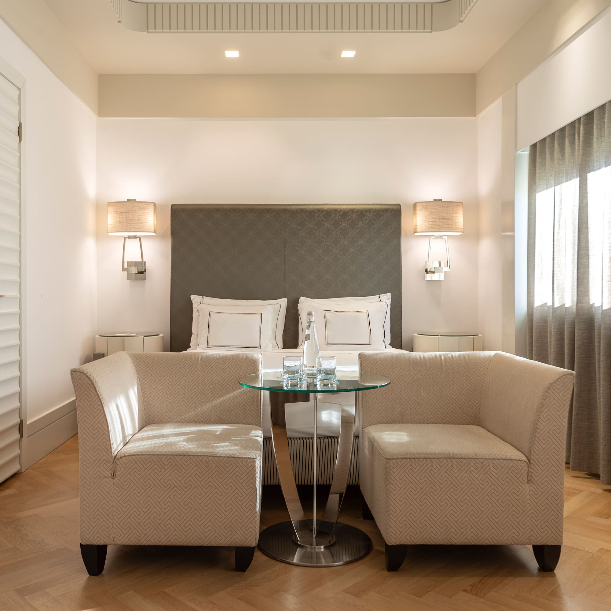 a room with a bed and two chairs