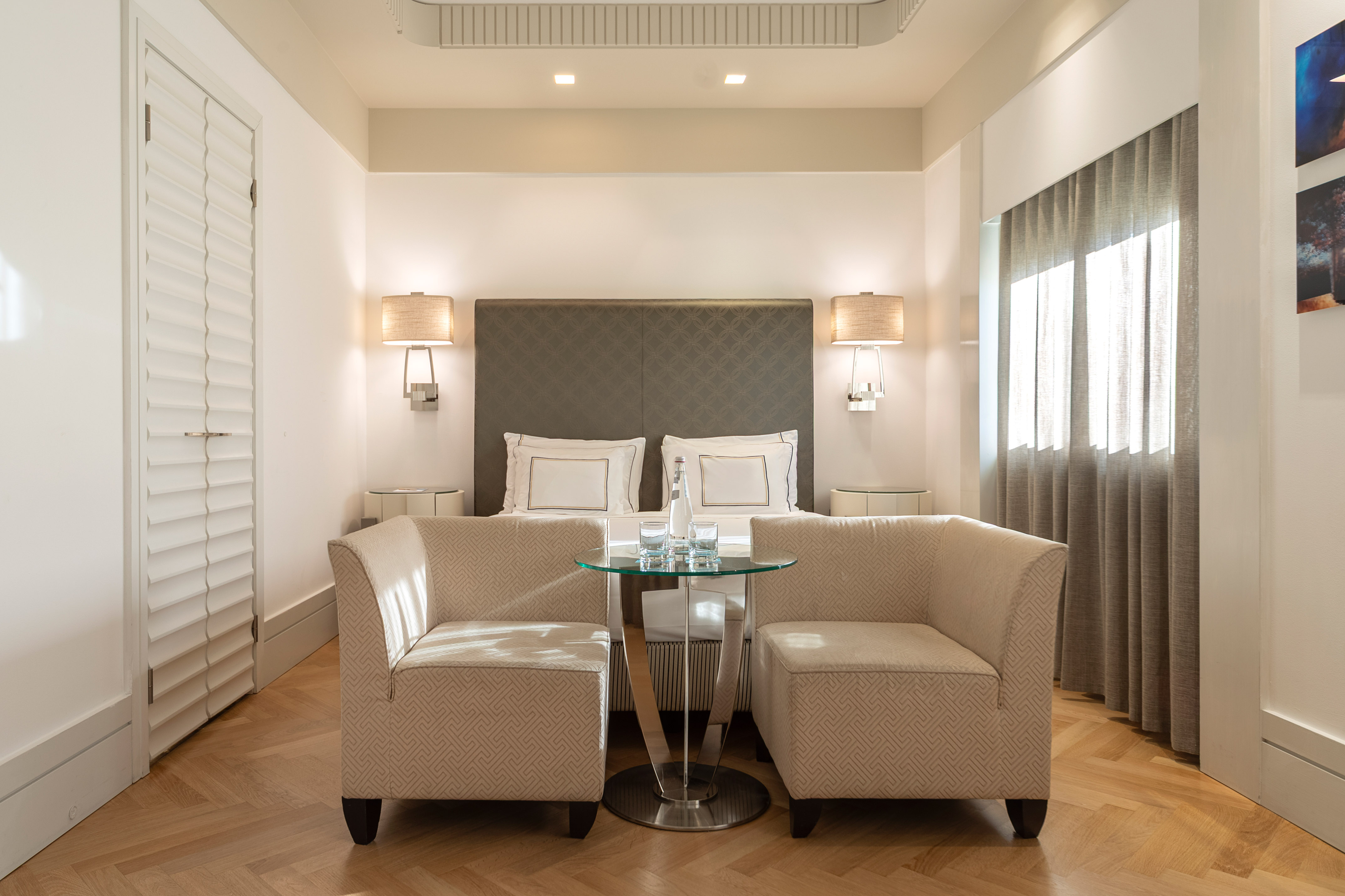 a room with a bed and two chairs