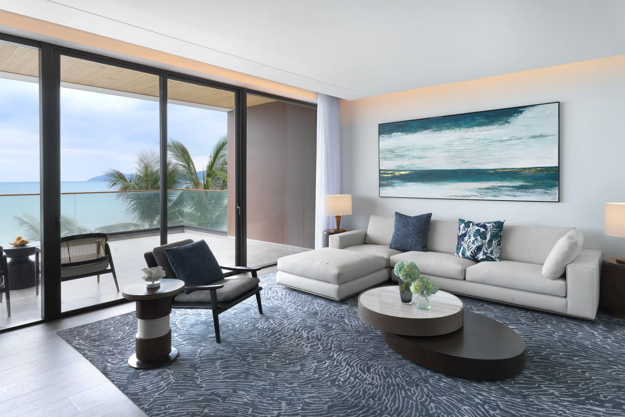 a living room with a large glass door and a large painting