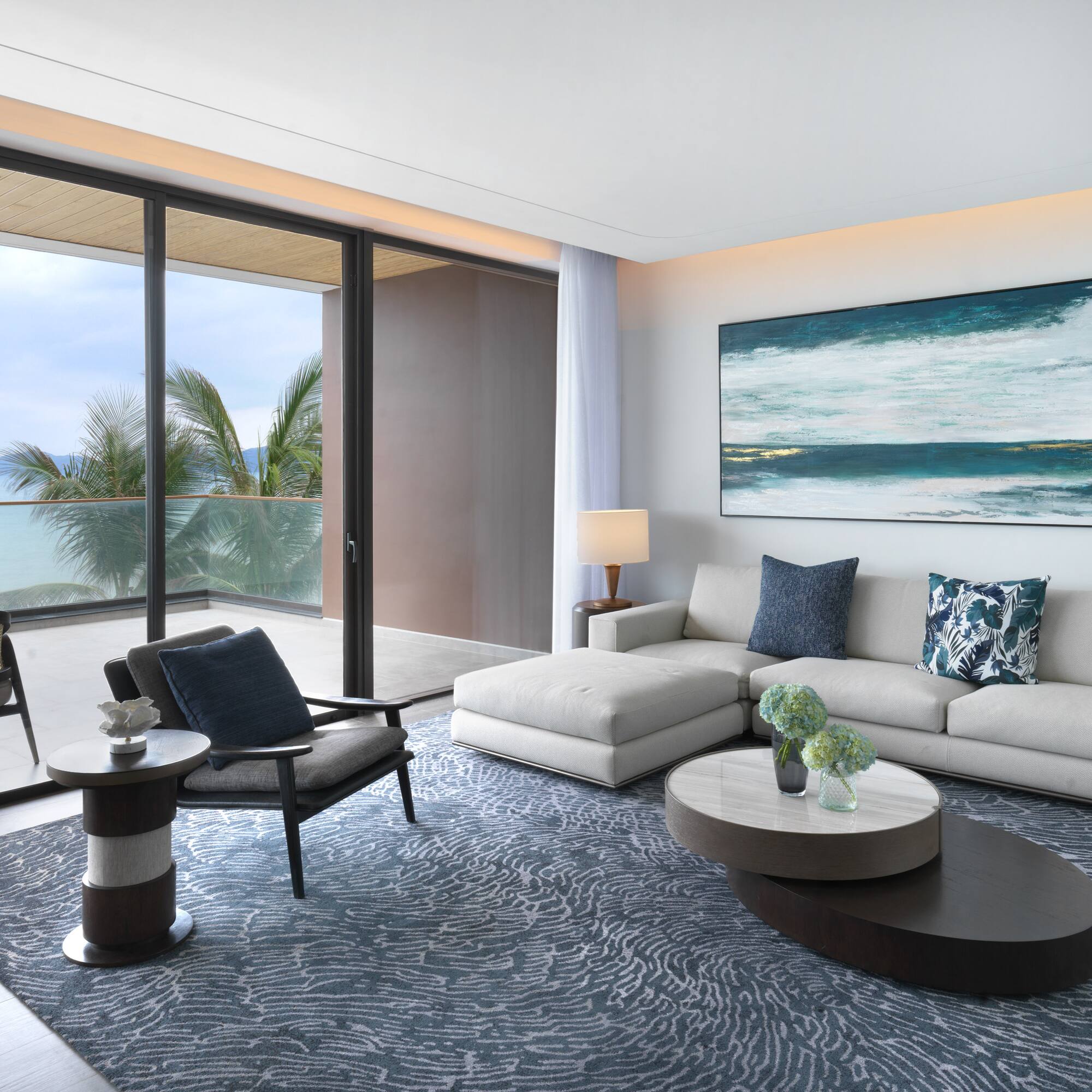 a living room with a large glass door and a large painting