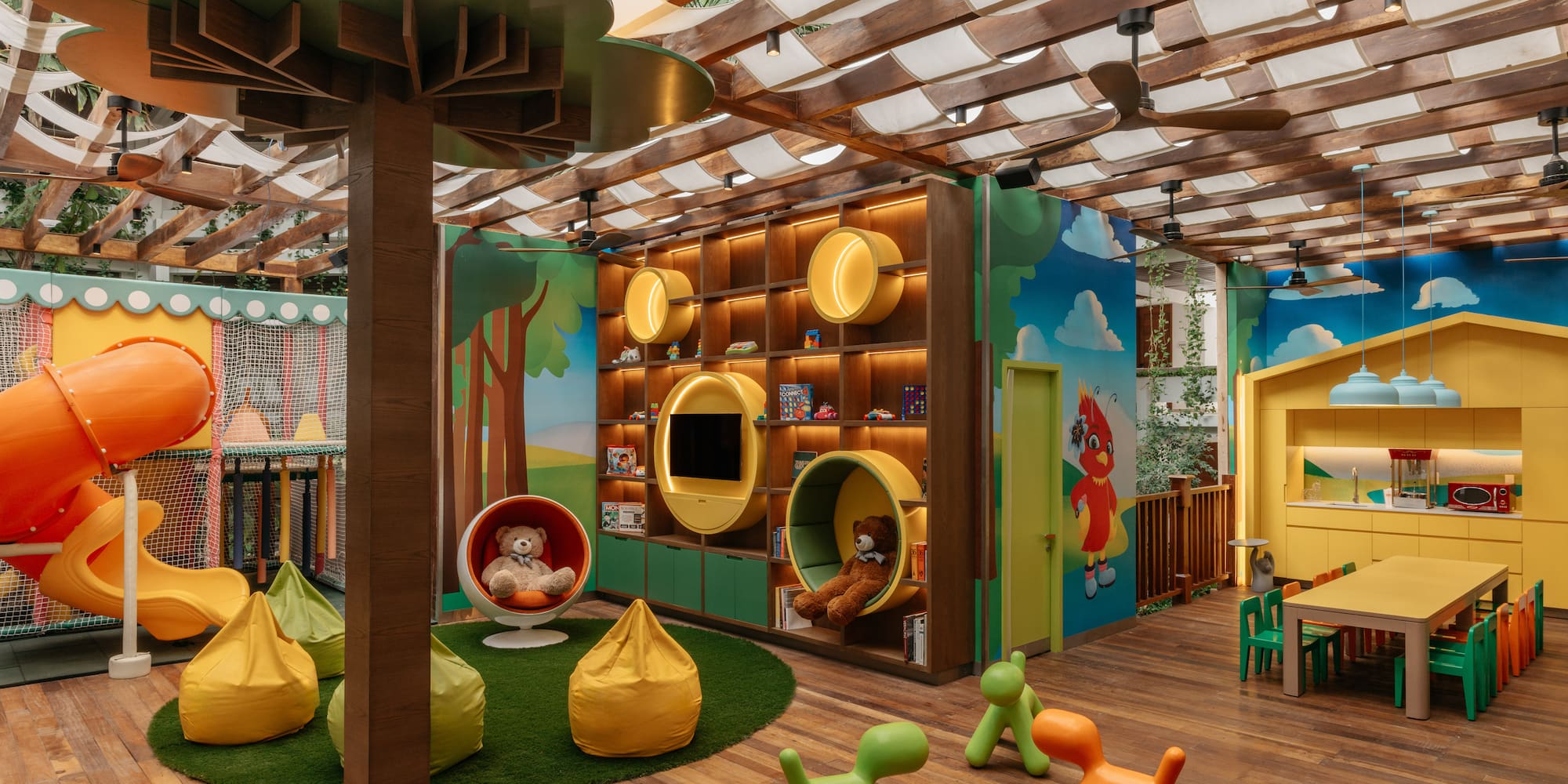 Vibrant indoor children's playroom with slide, toy shelves, and play kitchen.