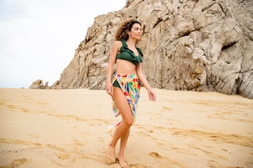 a woman in a garment and skirt on a beach