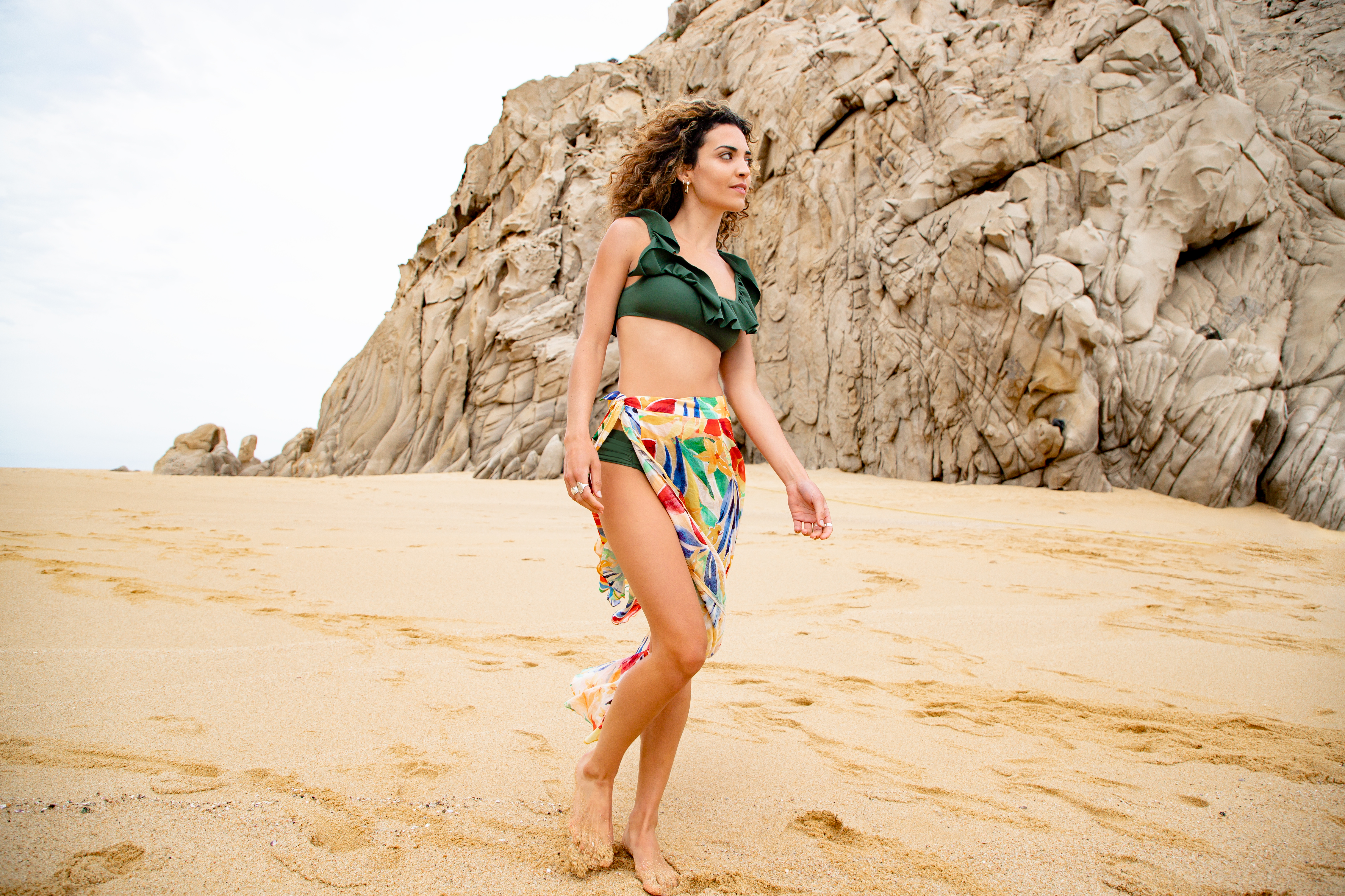 a woman in a garment and skirt on a beach