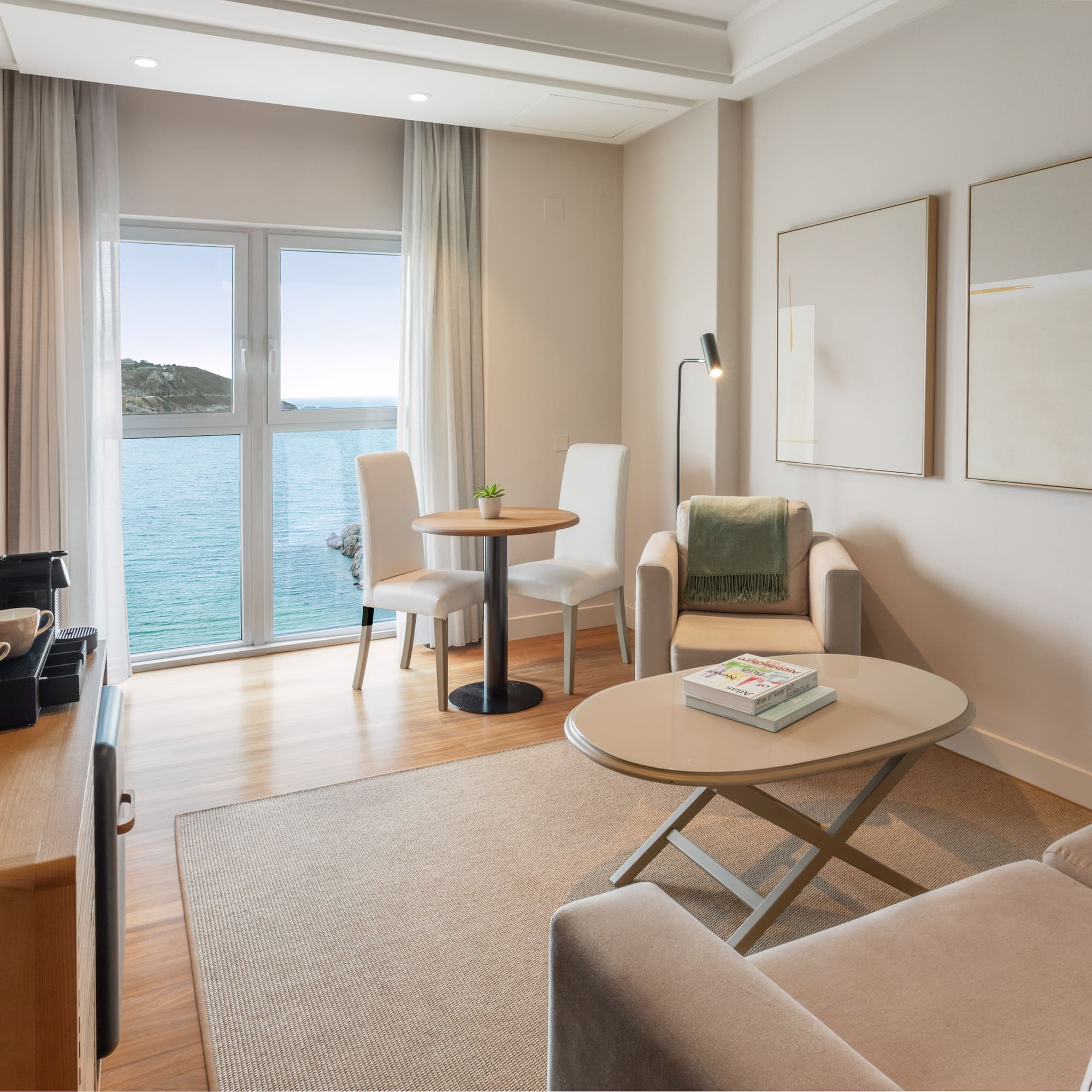 Luminosa suite de hotel moderna con vista al mar y sala de estar.