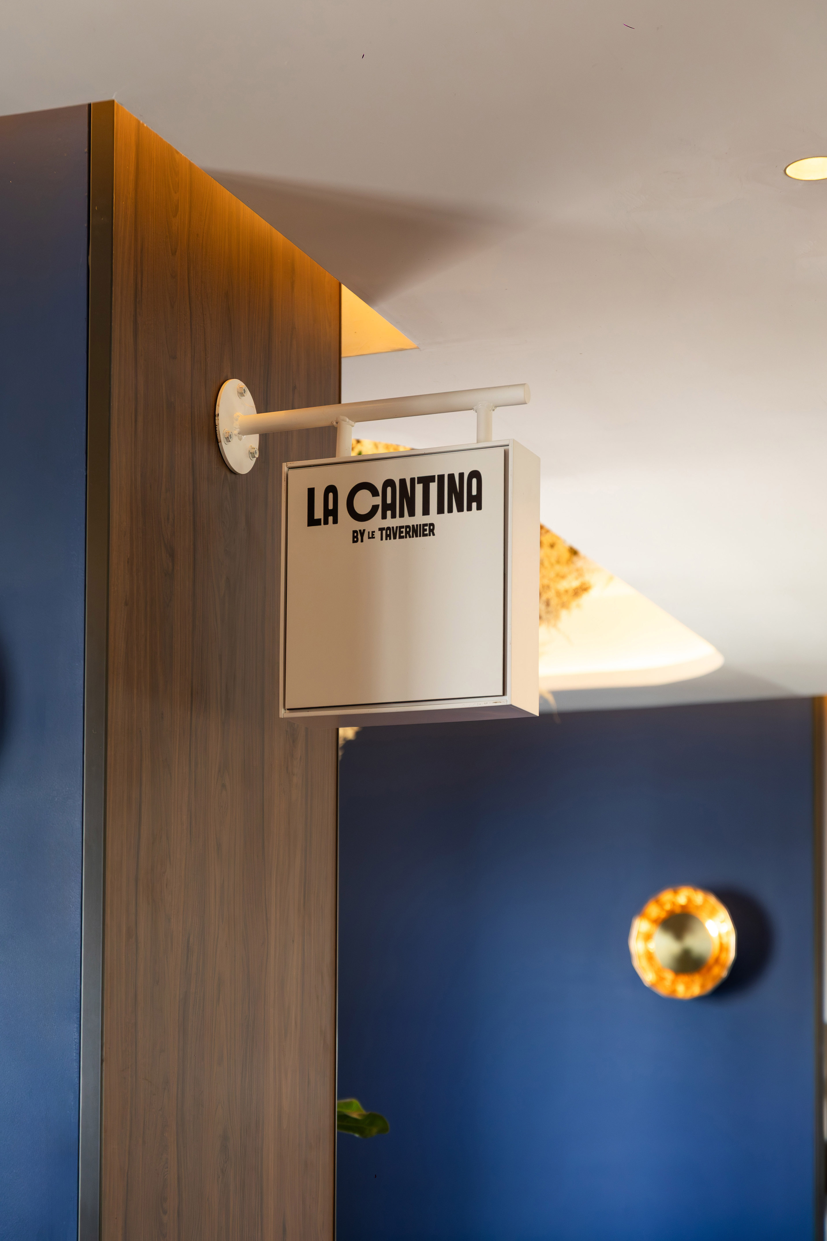 White La Cantina by Le Tavernier hanging sign on a dark wood panel.
