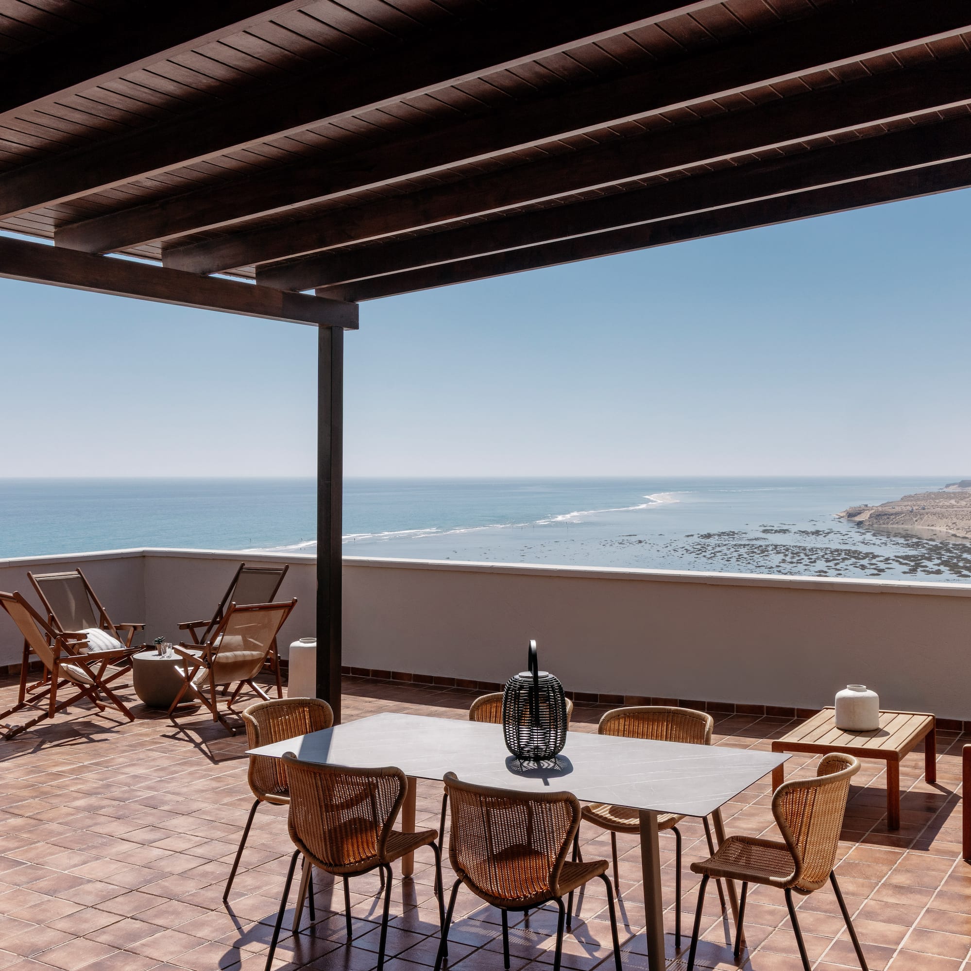 a patio with chairs and table on a tile floor