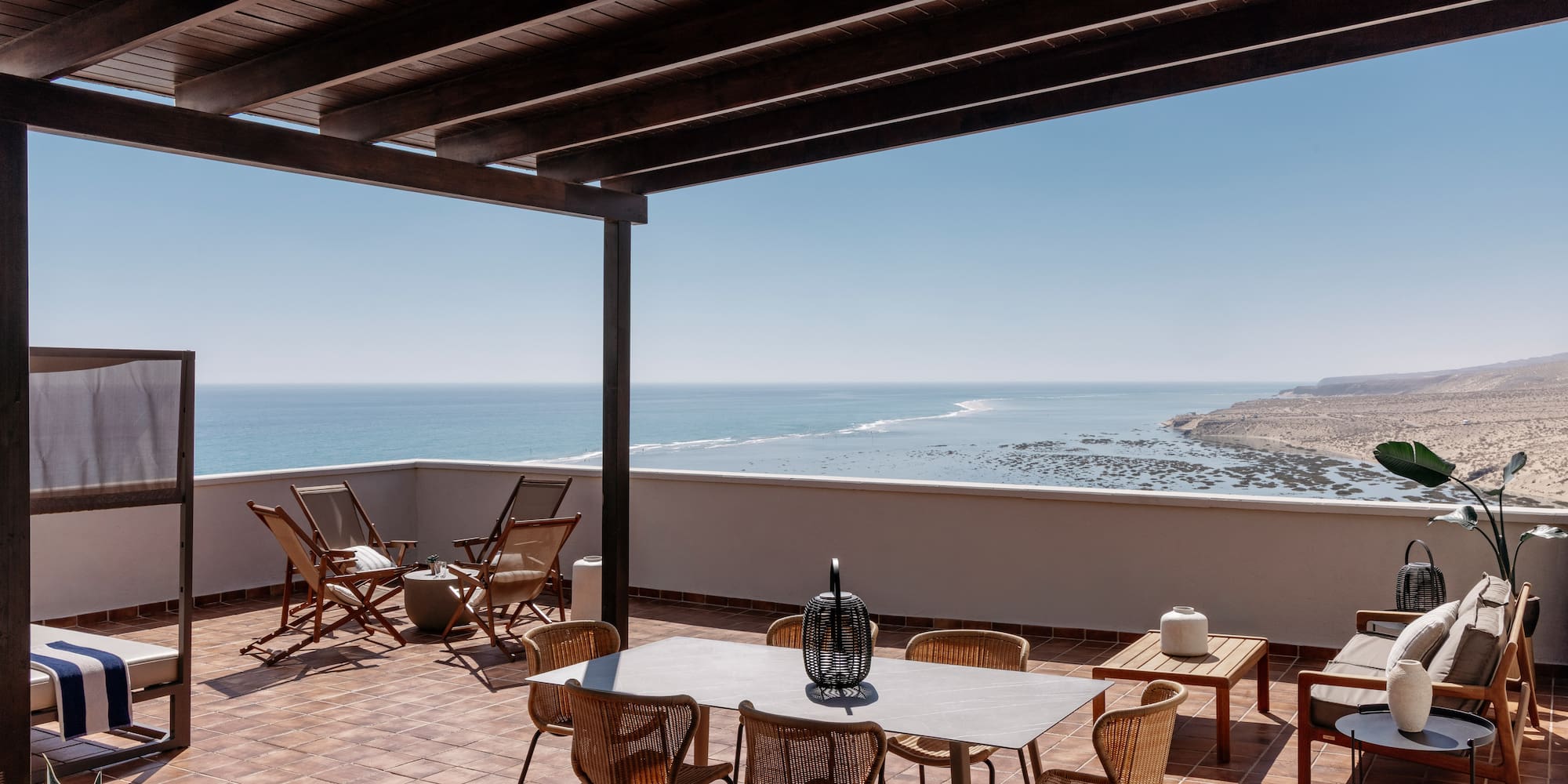 a patio with chairs and table on a tile floor