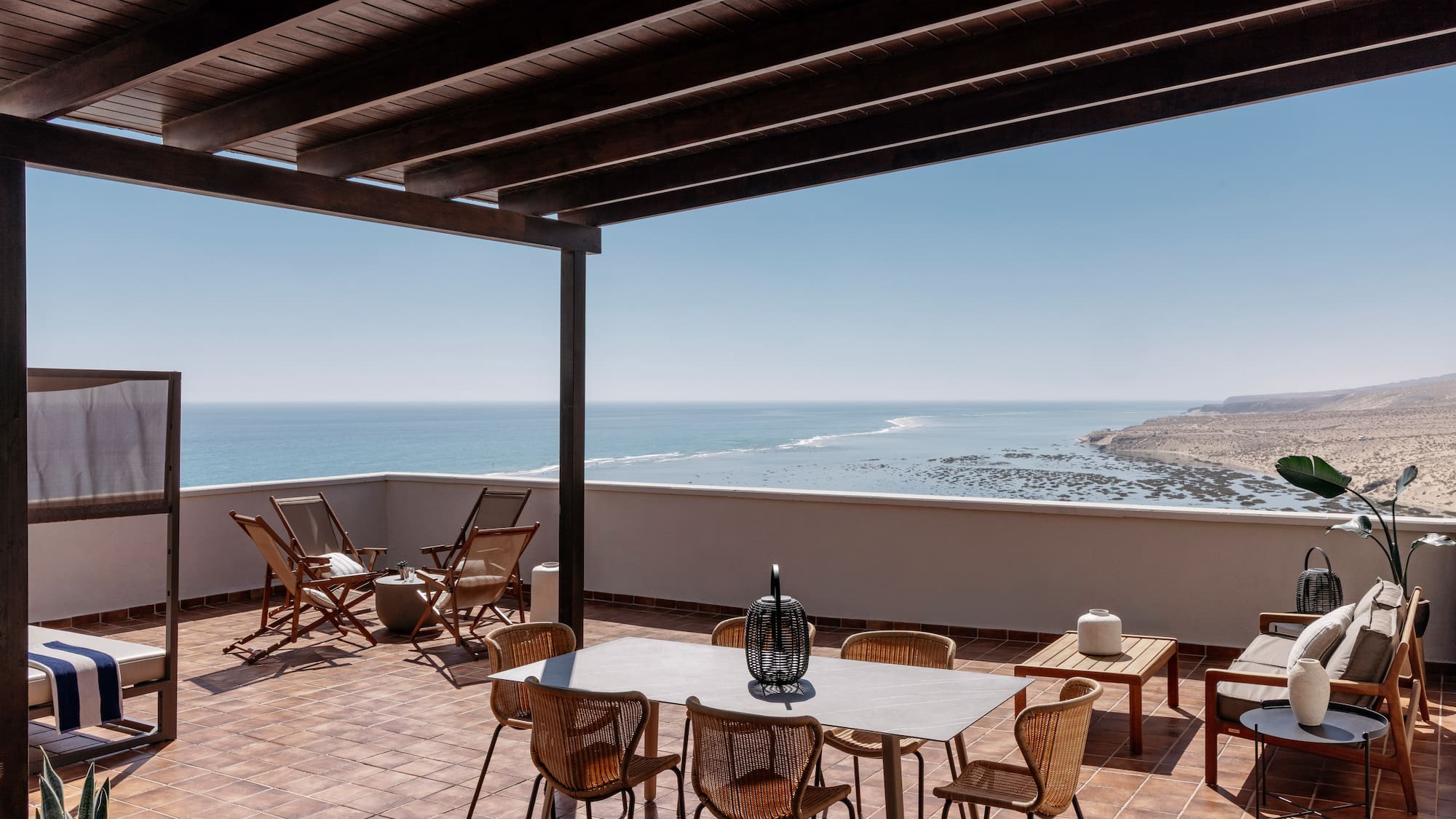 a patio with chairs and table on a tile floor