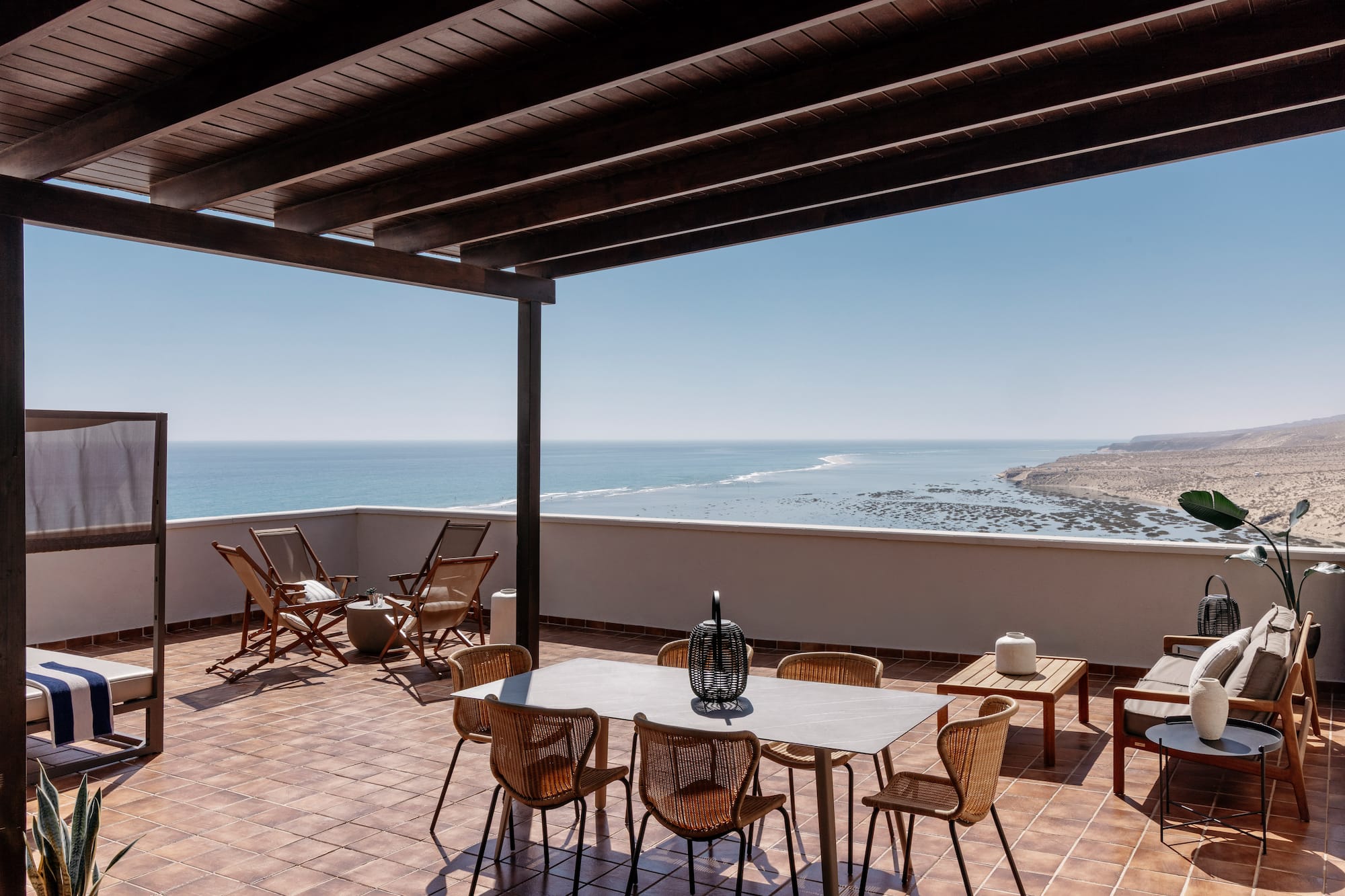 a patio with chairs and table on a tile floor