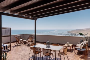 a patio with chairs and table on a tile floor